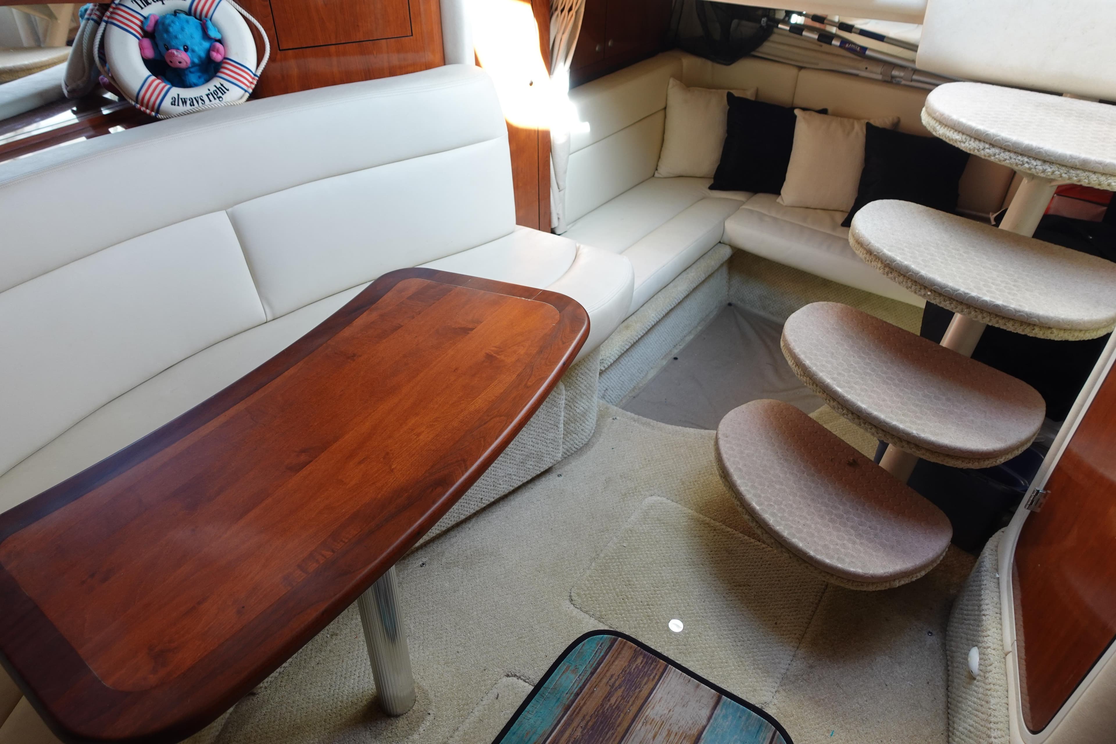 Interior of 2007 Sea Ray 320 Sundancer with cozy seating and wooden table.