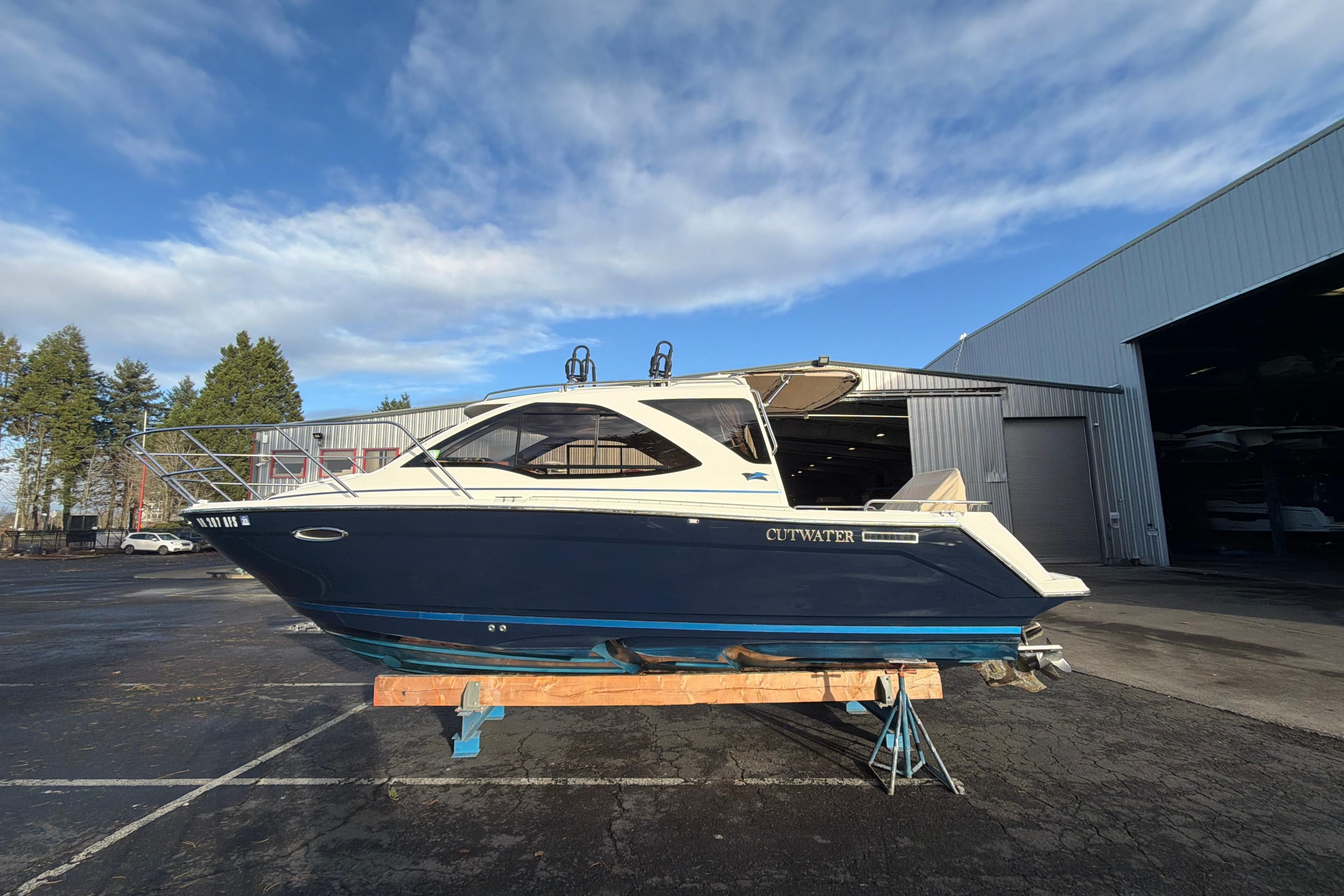 2016 Cutwater C-242 Coupe boat on a stand, outdoors near a warehouse.