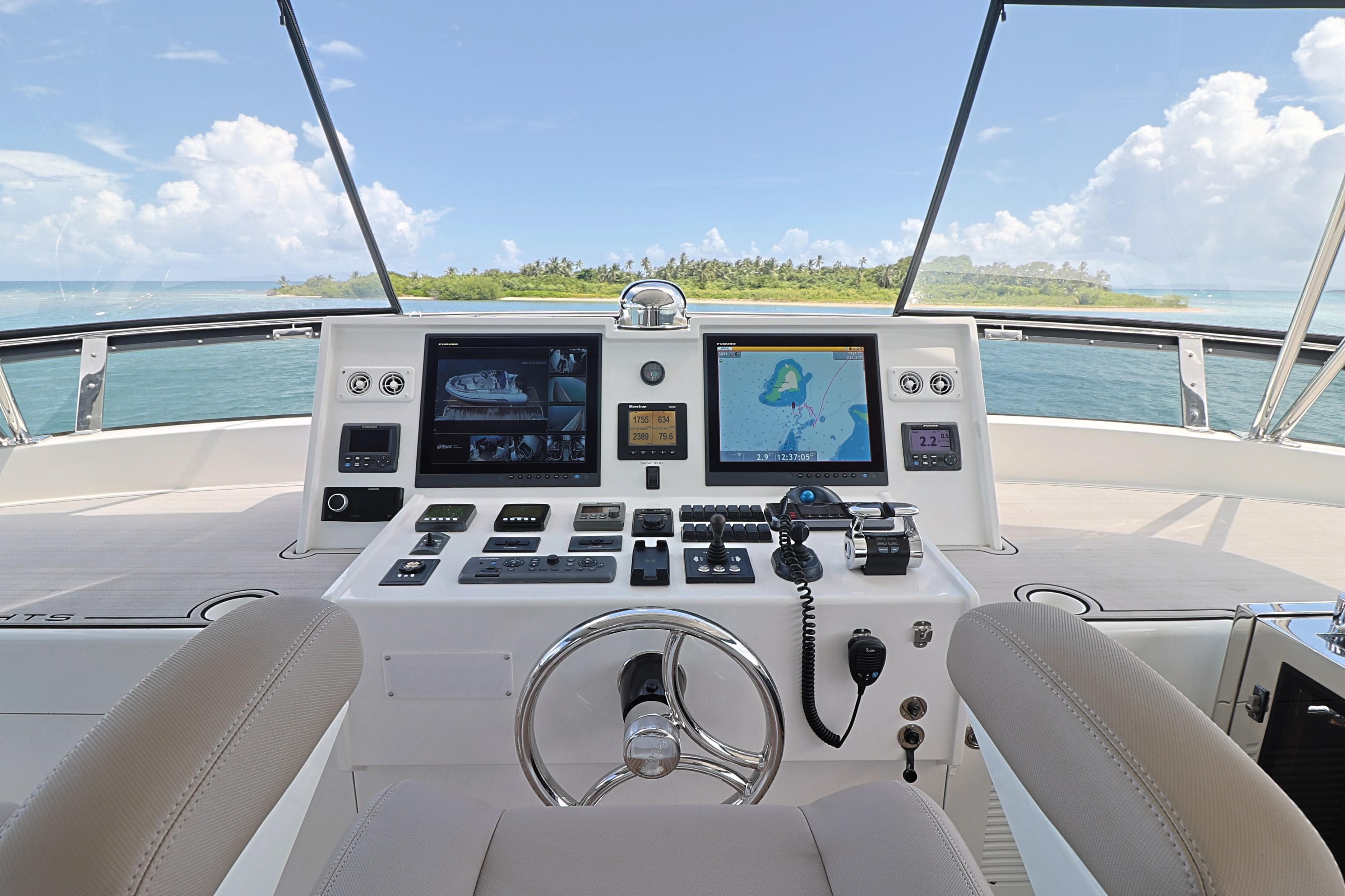 Helm of 2013 Cheoy Lee Bravo yacht with navigation screens and ocean view.