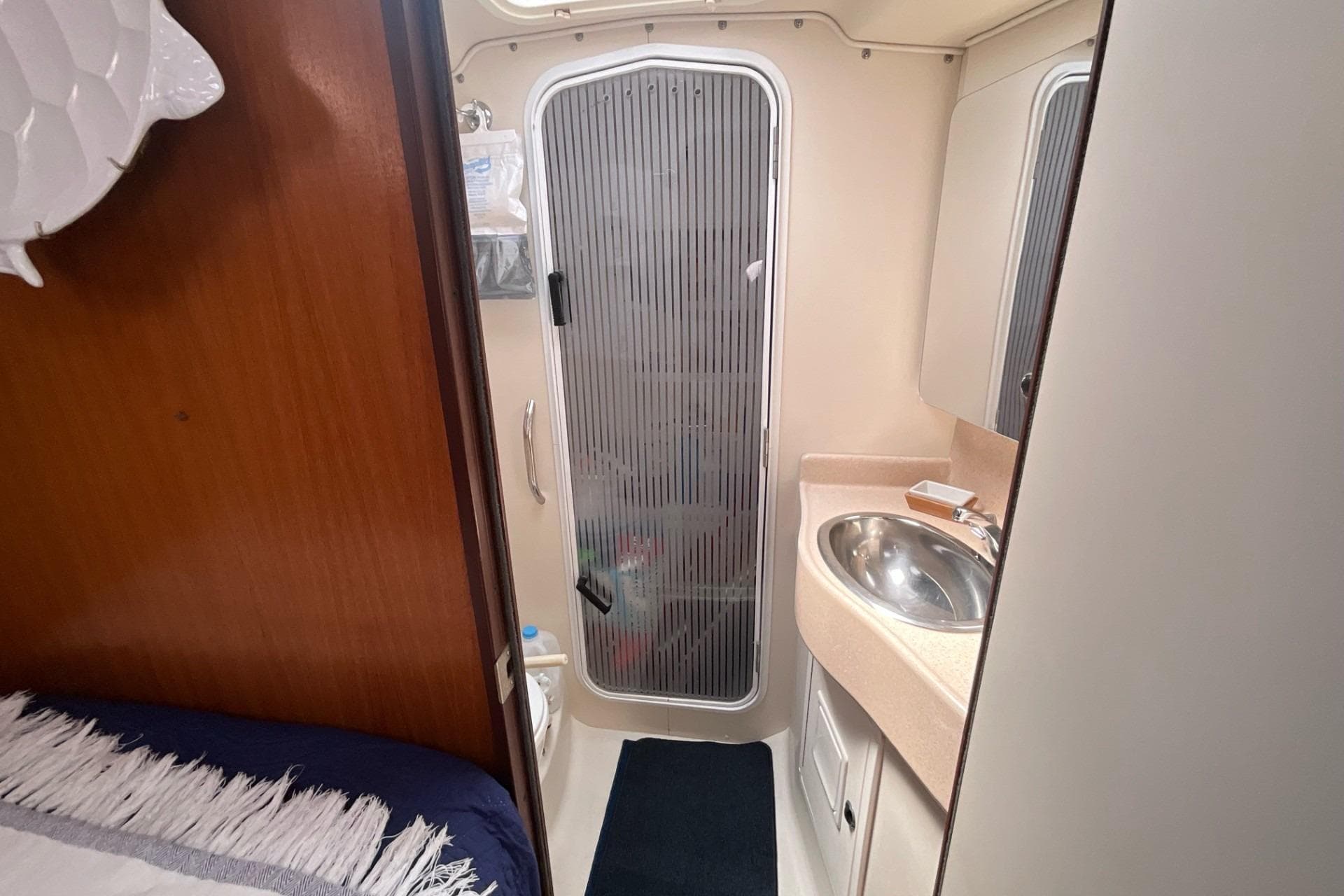 Catalina 470 yacht bathroom interior, featuring sink, shower, and wooden accents, year 2000 model.