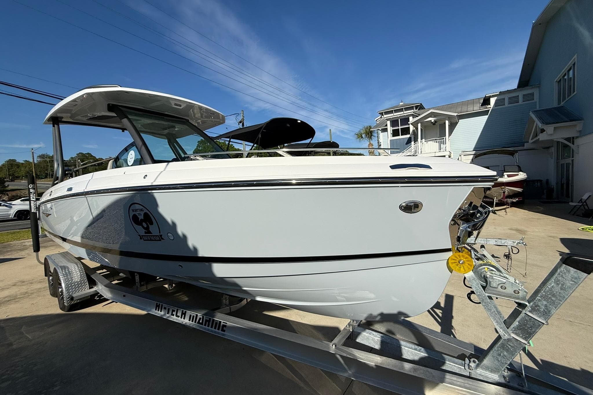 2026 Monterey Elite 27 OB boat on trailer, parked outdoors under clear blue sky.