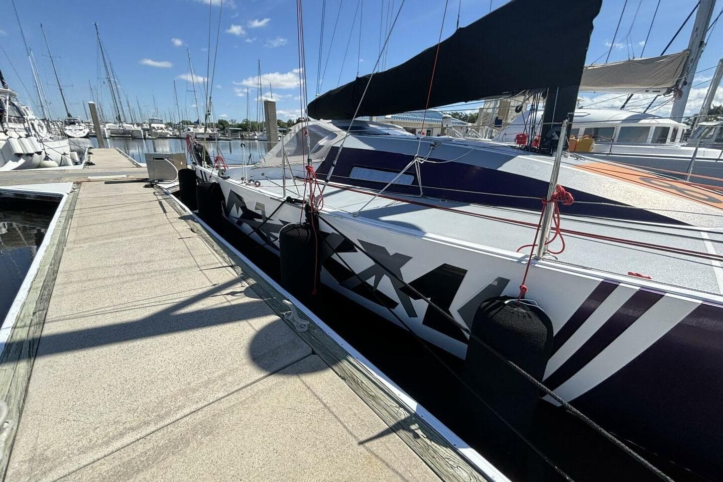 2009 Class 40 Akilaria RC2 sailboat docked at marina under clear blue sky.
