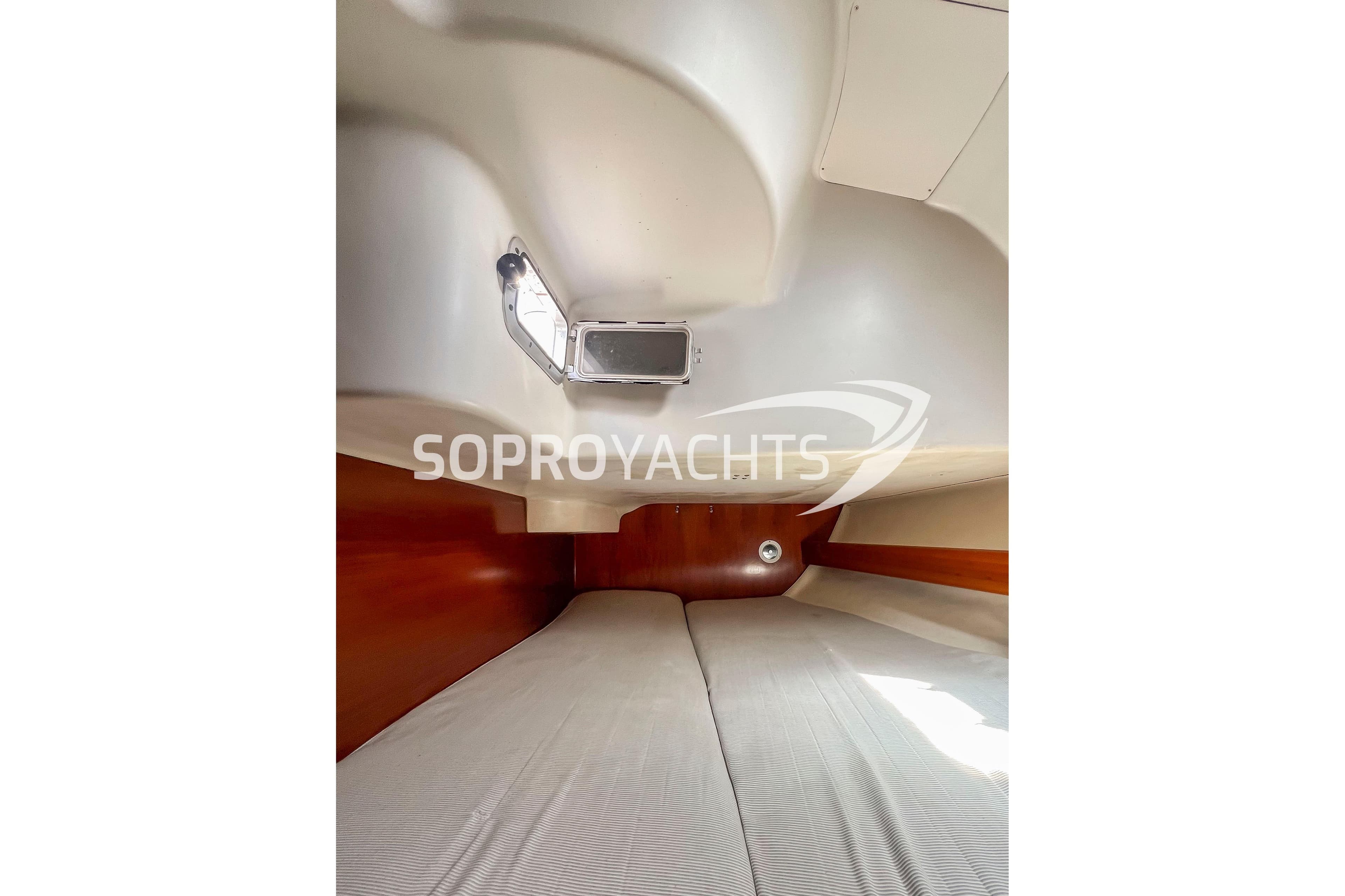 Interior cabin of 1991 Beneteau First 45f5 yacht with wooden accents and bedding.