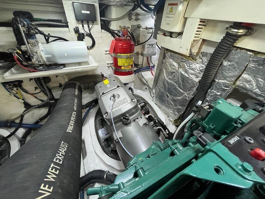 Engine room of a 2019 Schaefer 510 yacht with visible machinery and fire extinguisher.