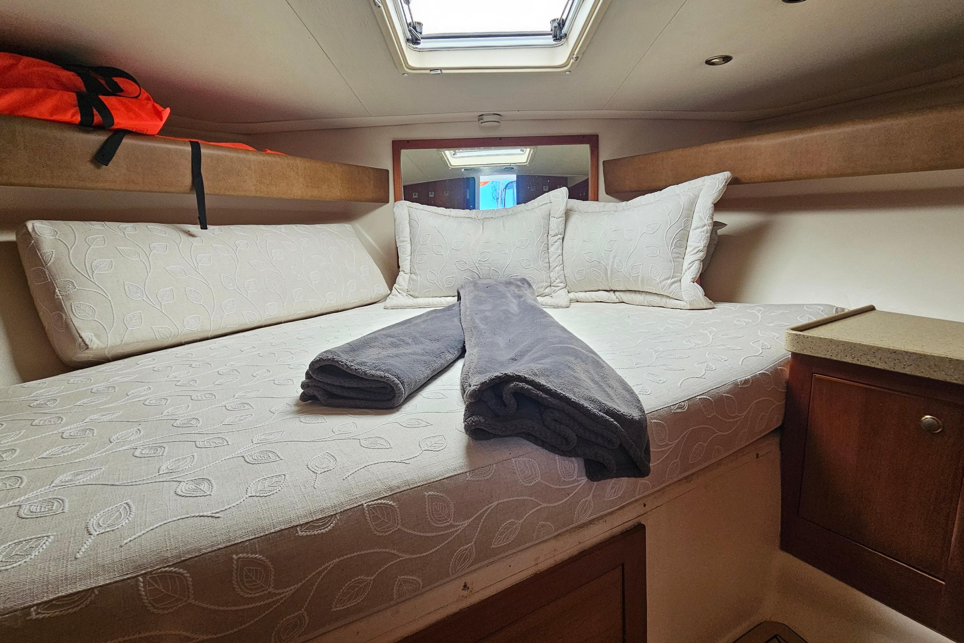 Cozy cabin interior of 2004 Luhrs 34 Convertible with bed and pillows.