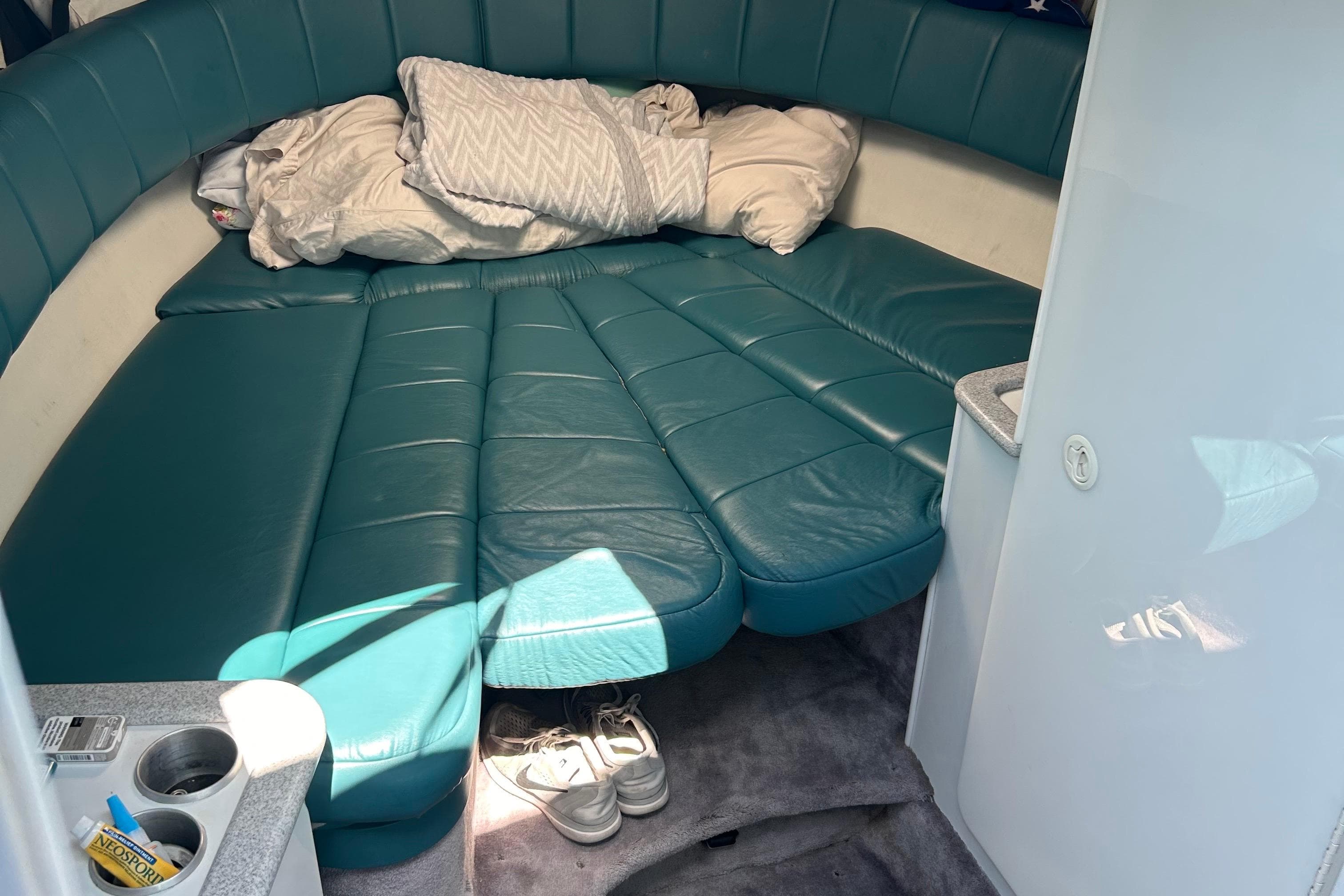 Interior cabin of a 1995 Formula 280 Sun Sport boat with teal seating and bedding.