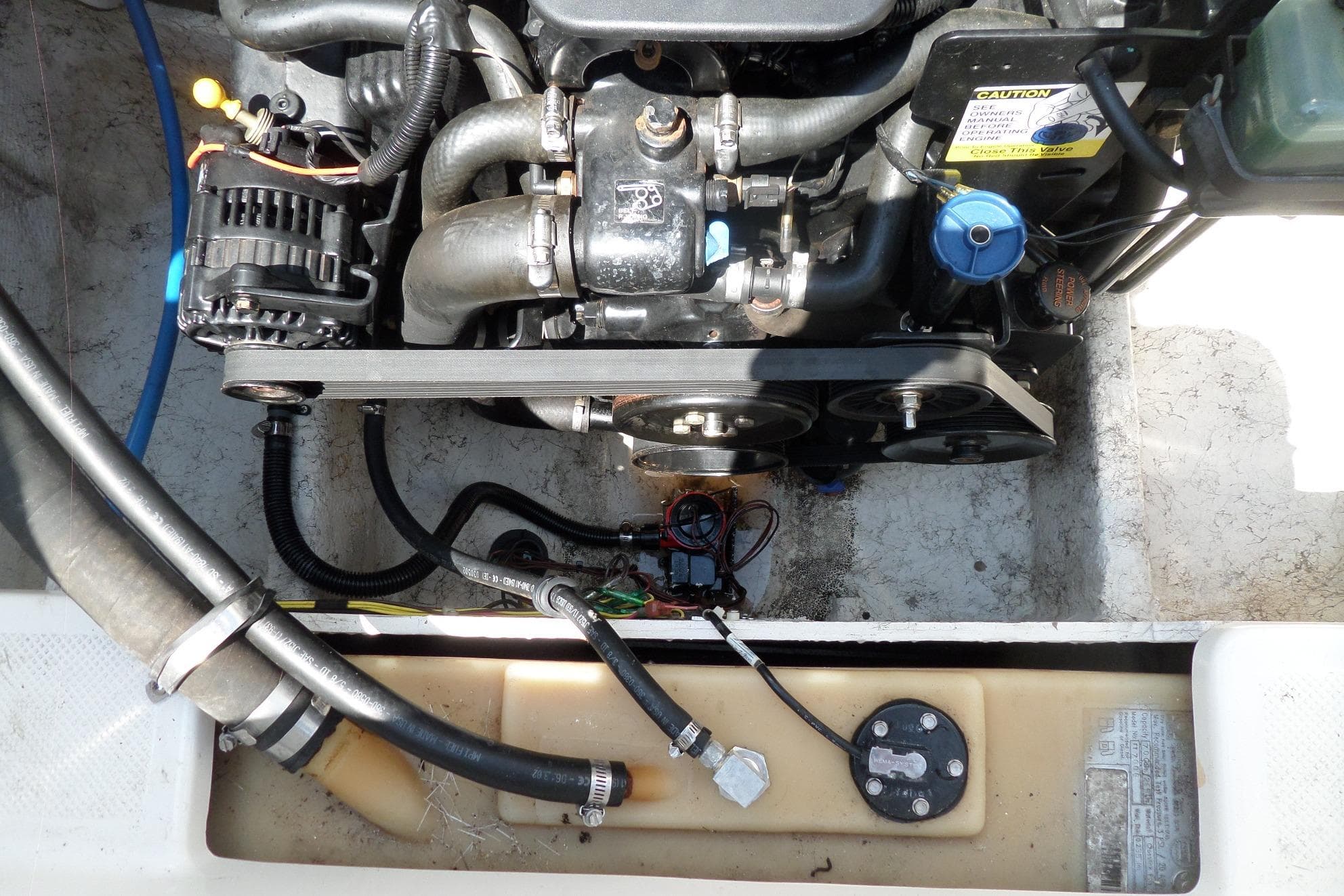 Engine compartment of a 2003 Maxum 2400 SC boat, showing detailed components and hoses.