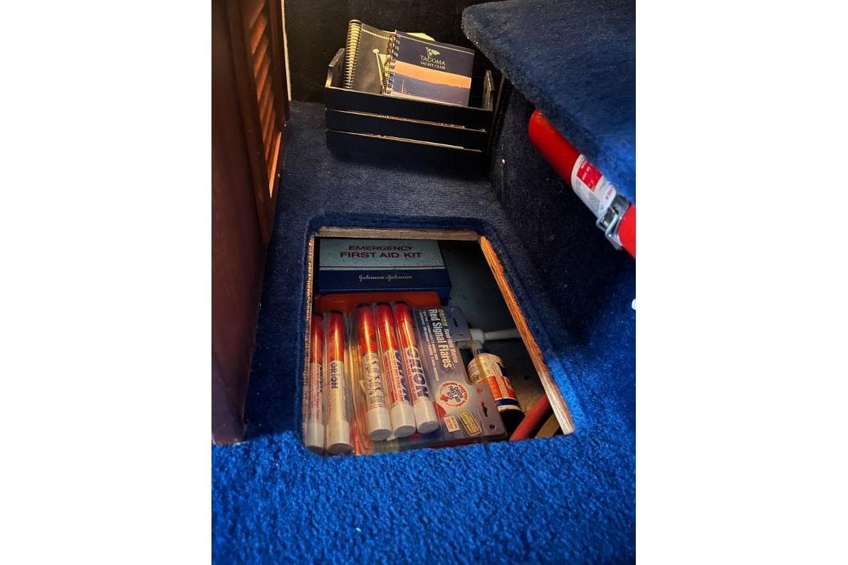 1976 Uniflite 32 Sport Sedan interior storage with first aid kit and emergency supplies.