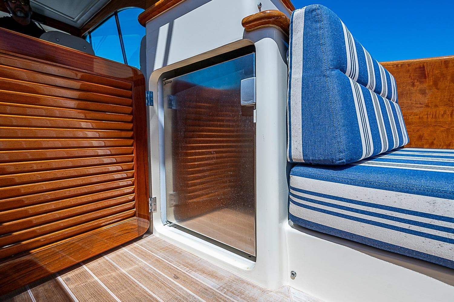 2016 Hinckley Picnic Boat 37 MKIII interior with striped seating and wooden accents.