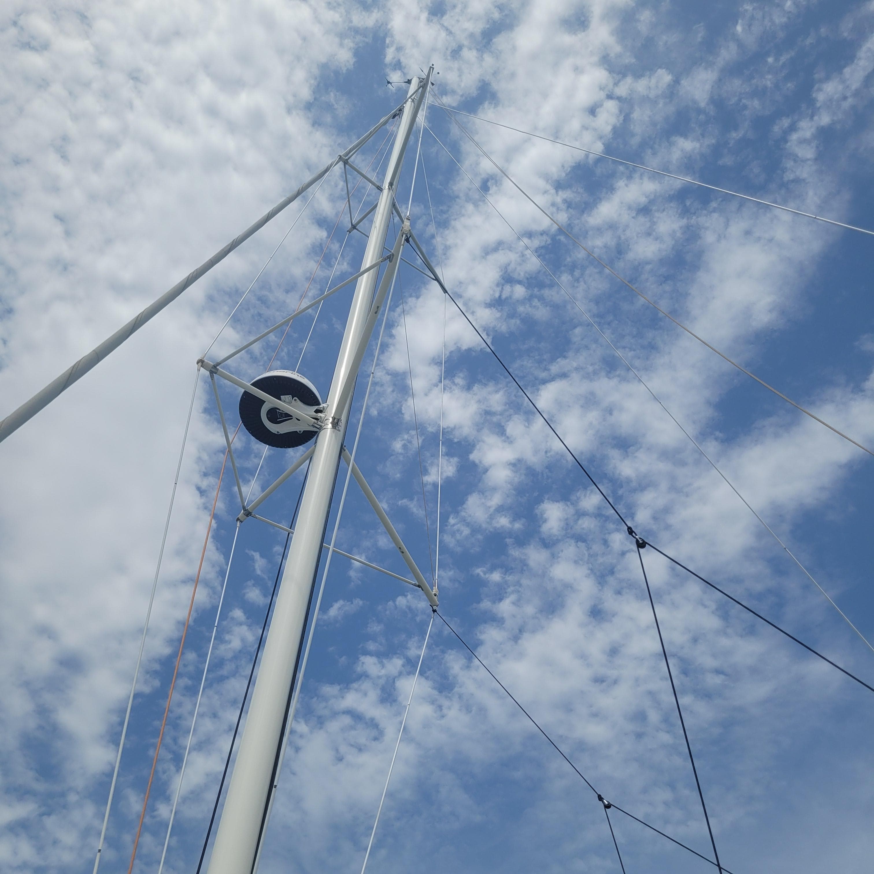 Mast of 2021 Dragonfly 32 Evolution sailboat against a cloudy blue sky.