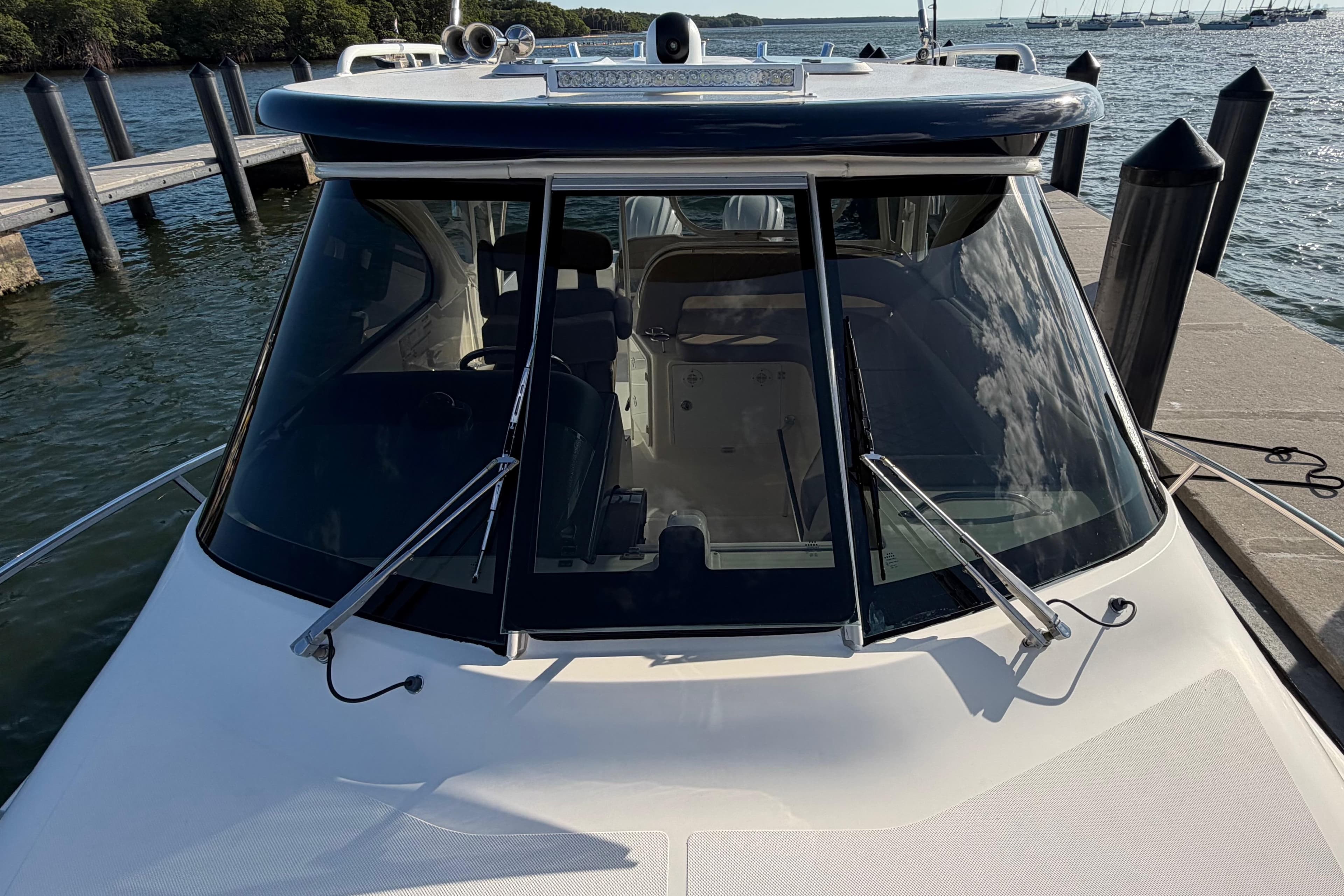 2009 Pursuit OS 315 Offshore boat docked, showcasing sleek windshield design and wipers.