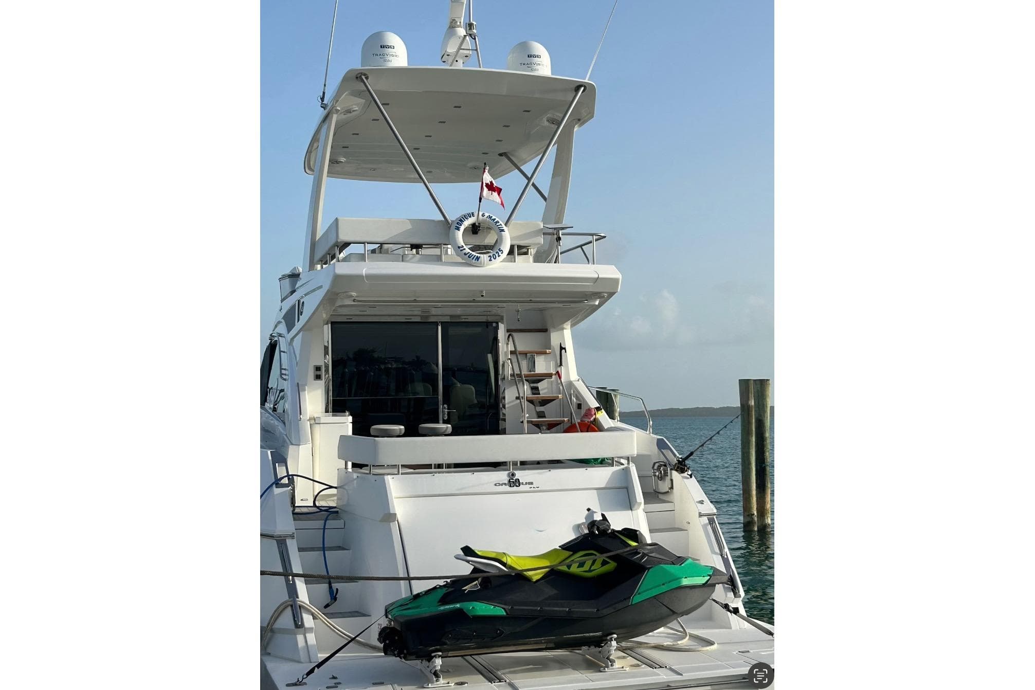 2017 Cruisers Yachts 60 Fly with jet ski on deck, docked by the water.