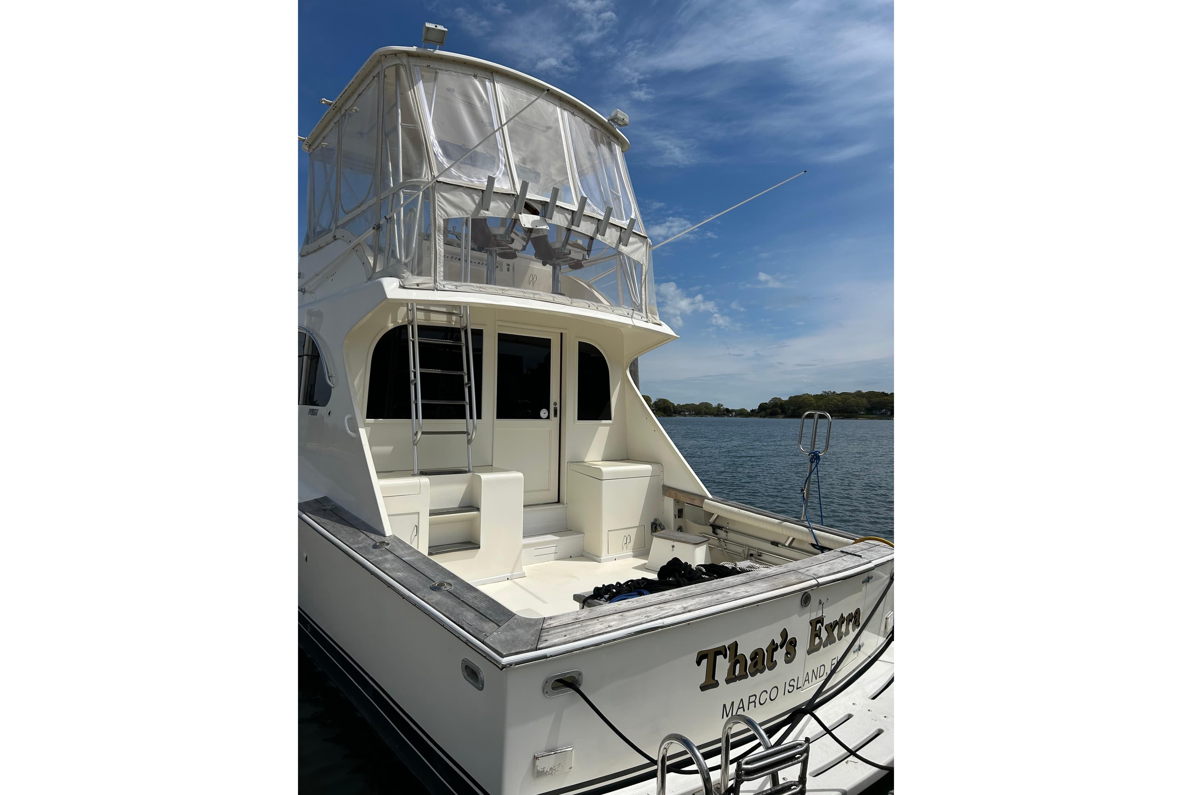 1990 Post 46 Convertible yacht docked, featuring a spacious deck and flybridge under a clear sky.