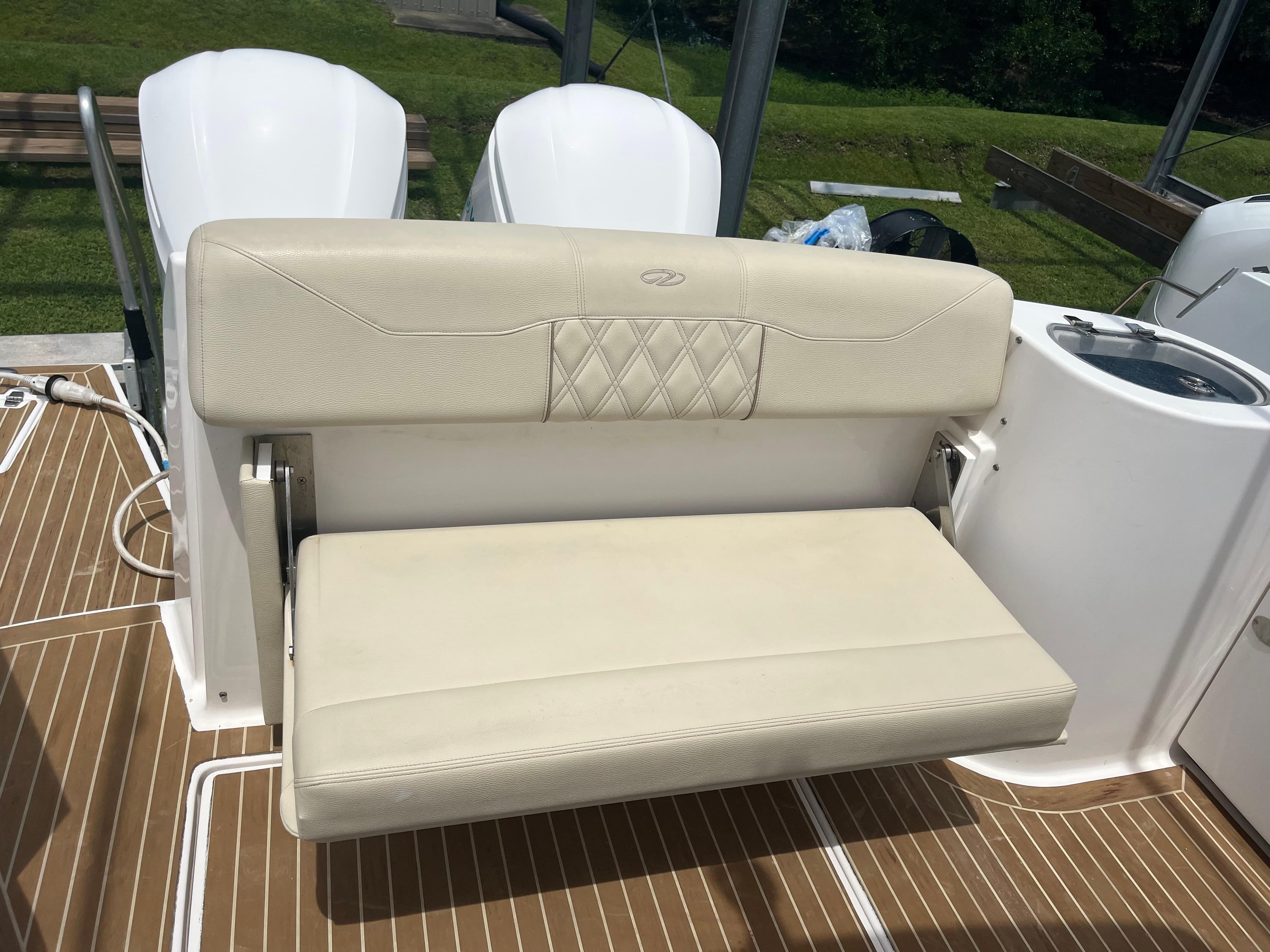 2019 Regal 33 SAV boat seat with white upholstery and teak flooring.