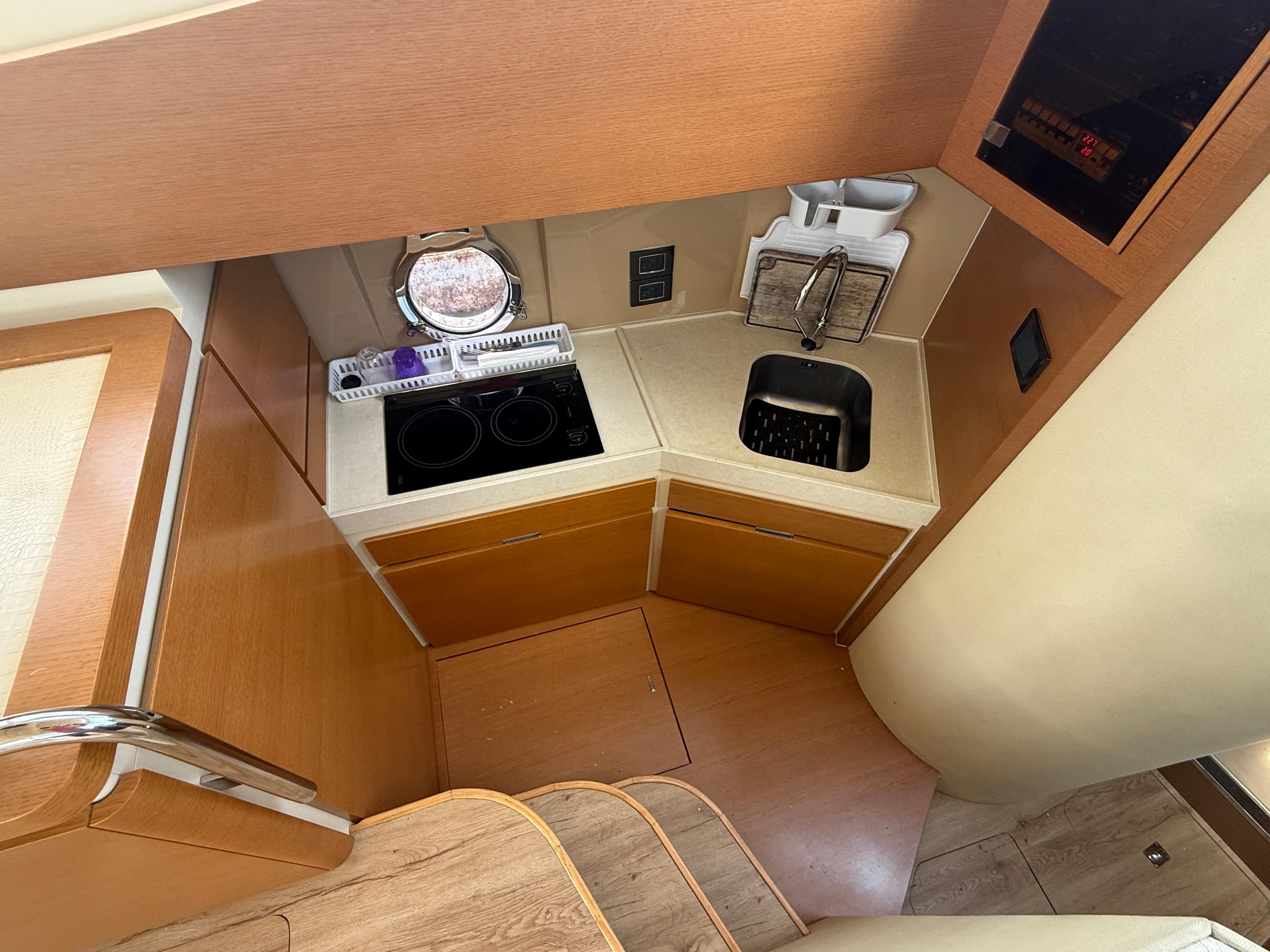 Compact kitchen area in 2018 Azimut 42 Fly yacht with stove and sink.
