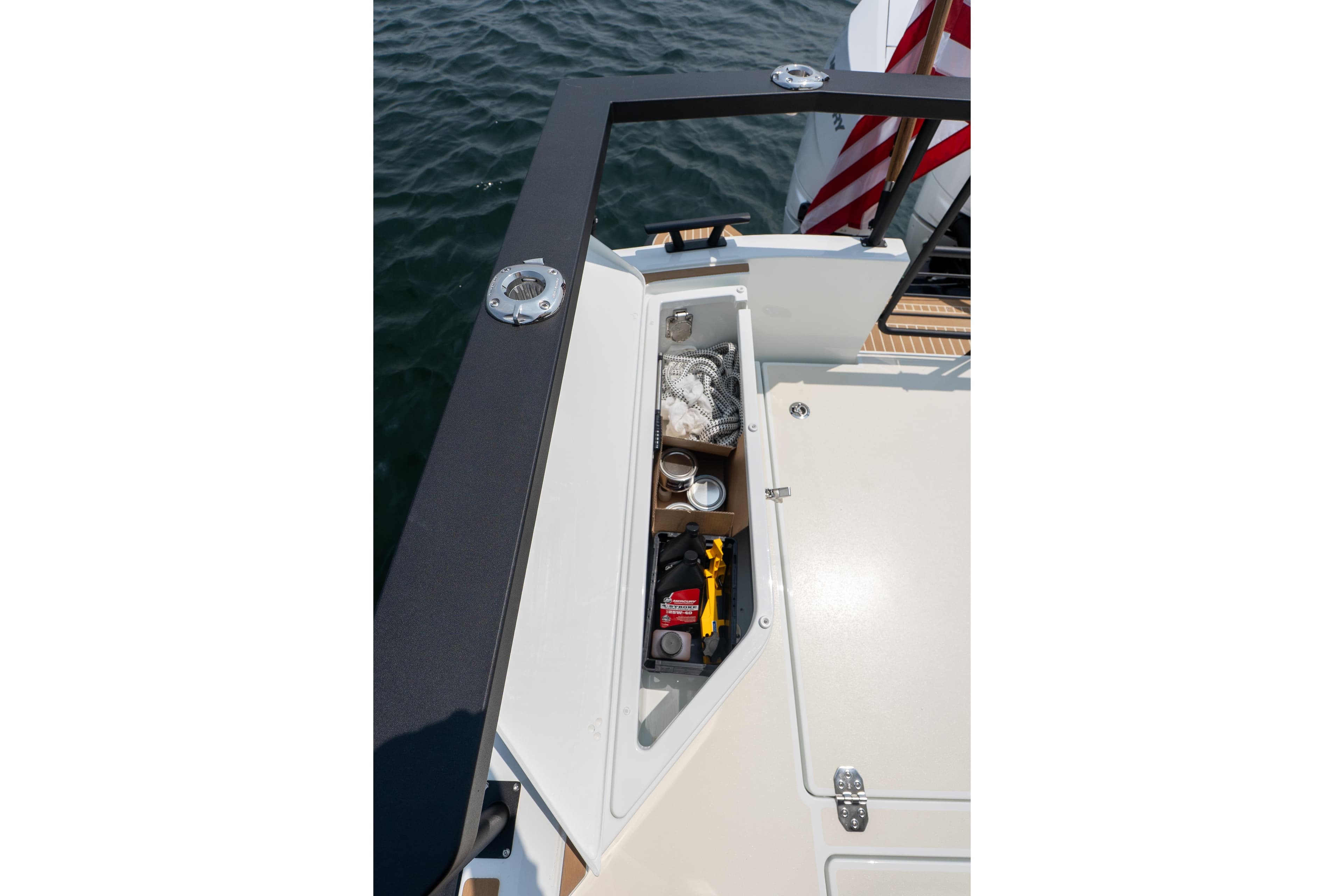 Storage compartment on 2027 Targa 32 OB boat, open with various items inside.