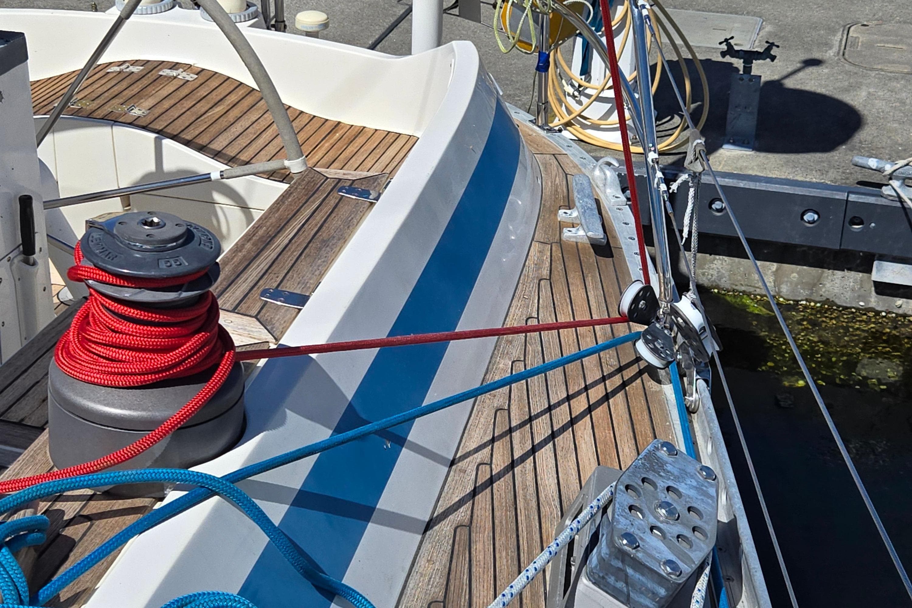 Deck of 1985 Swan 46 sailboat with ropes and winch in marina.
