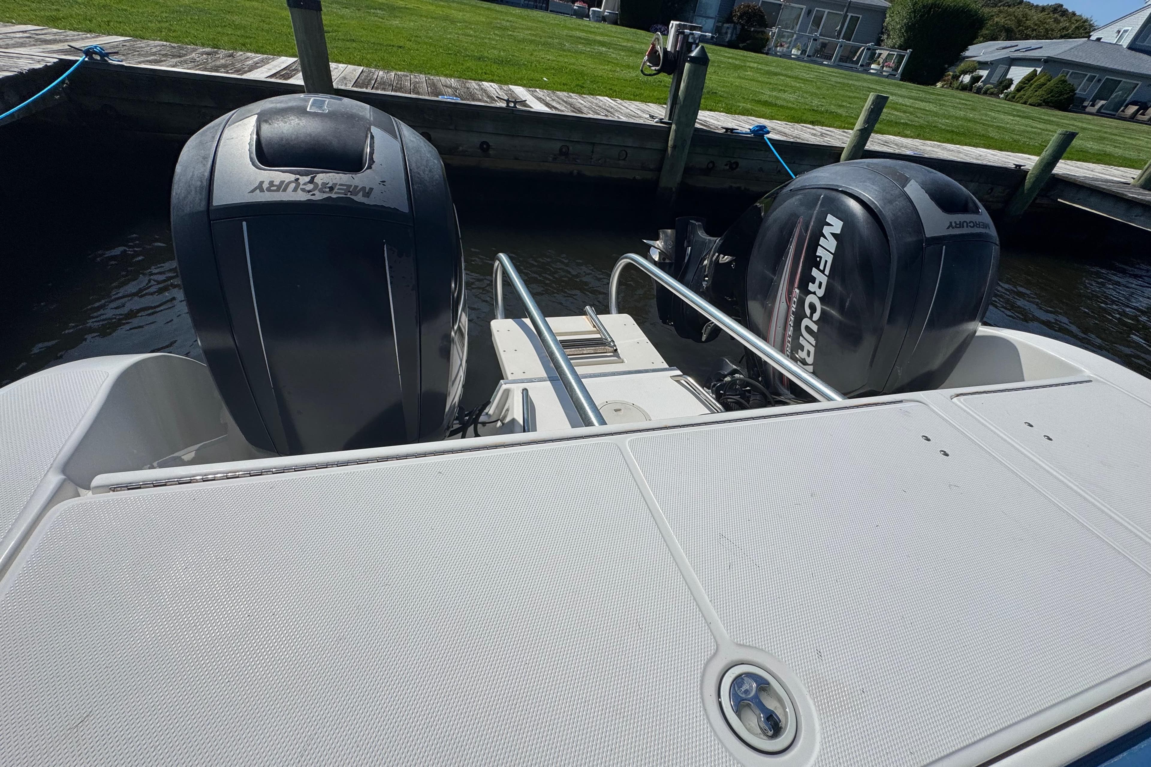 World Cat 246 DC boat with dual Mercury outboard engines docked by the water.