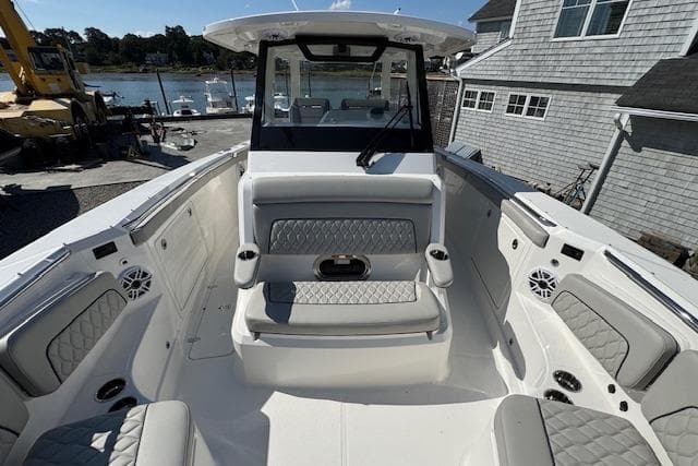 2026 Pursuit S 328 Sport boat interior with cushioned seating and waterfront view.