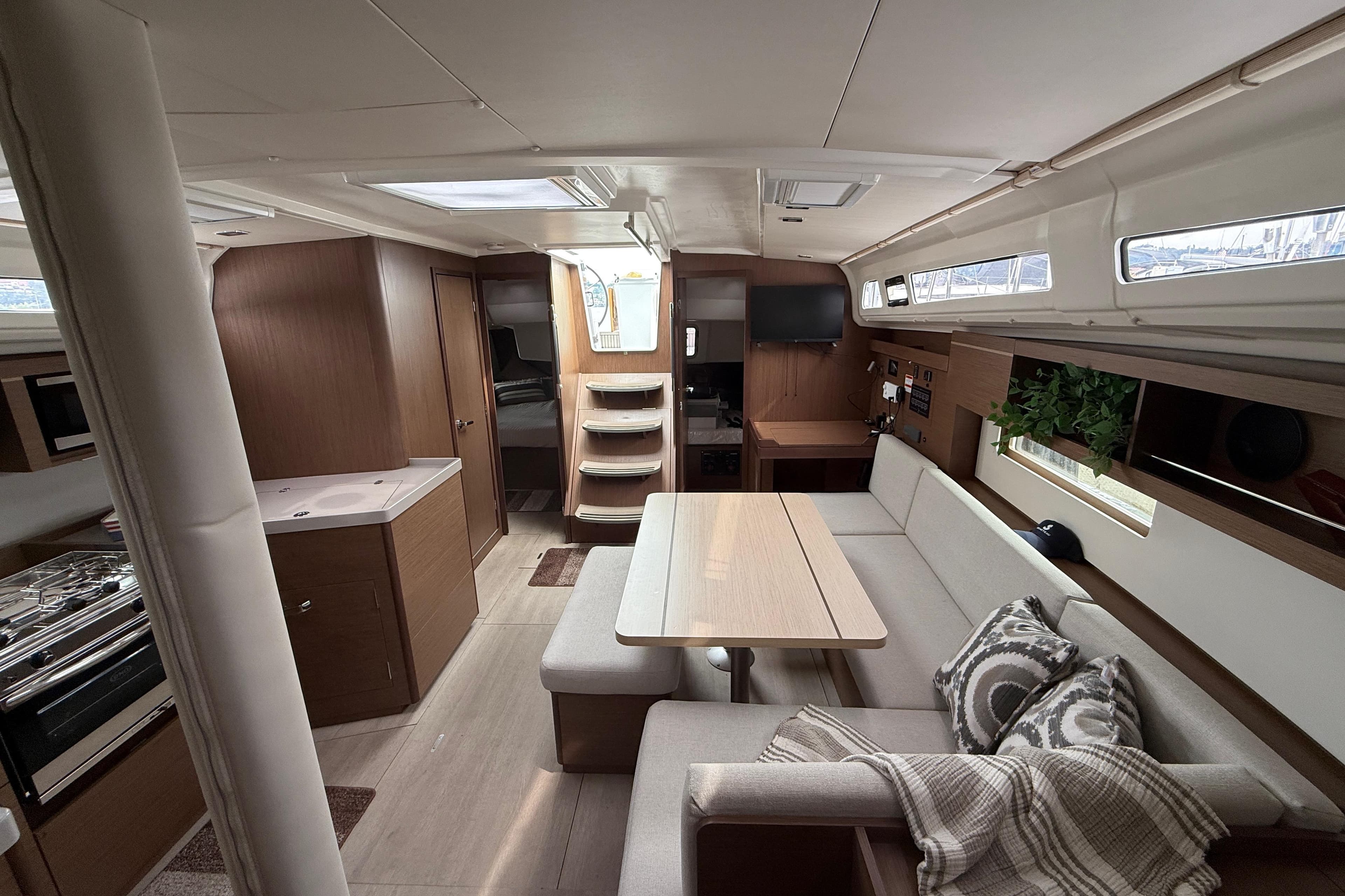 Interior of 2022 Beneteau Oceanis 40.1 yacht, featuring modern kitchen and cozy seating area.