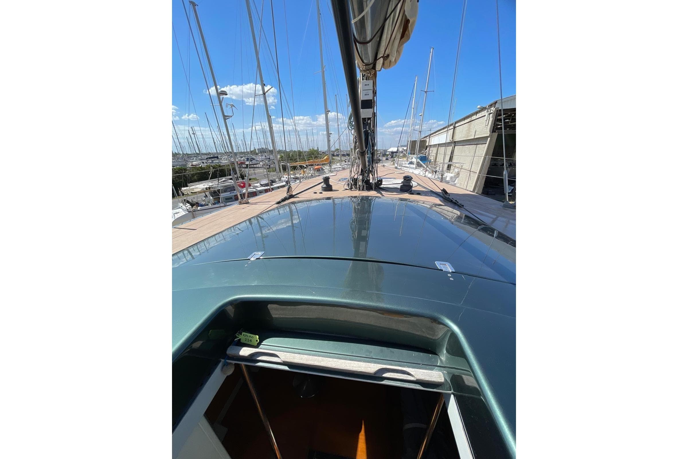 2003 Maxi Dolphin 65 yacht deck view with clear blue sky and marina background.