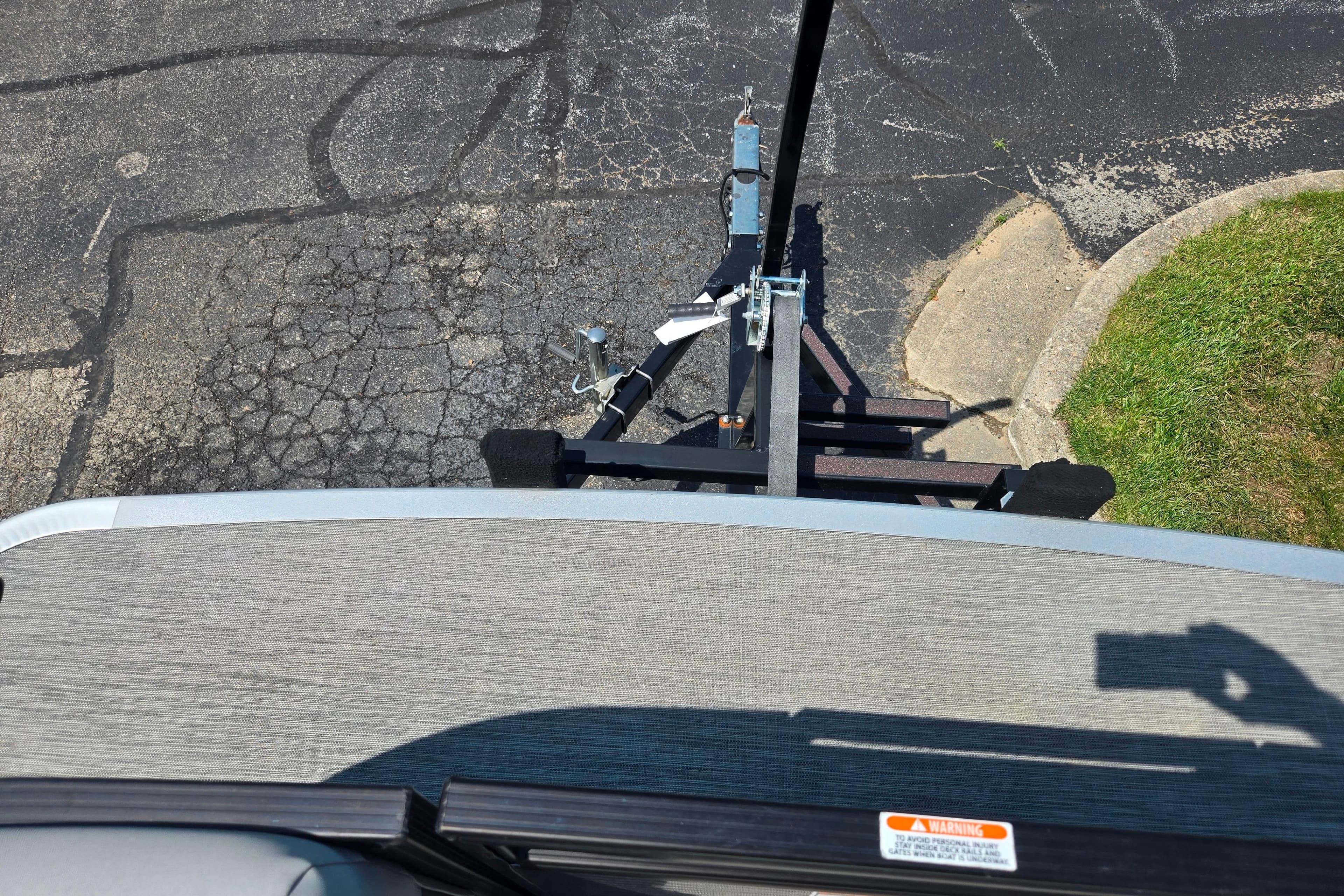 Top view of a 2020 Bennington SX 21 SLX boat trailer on cracked pavement.