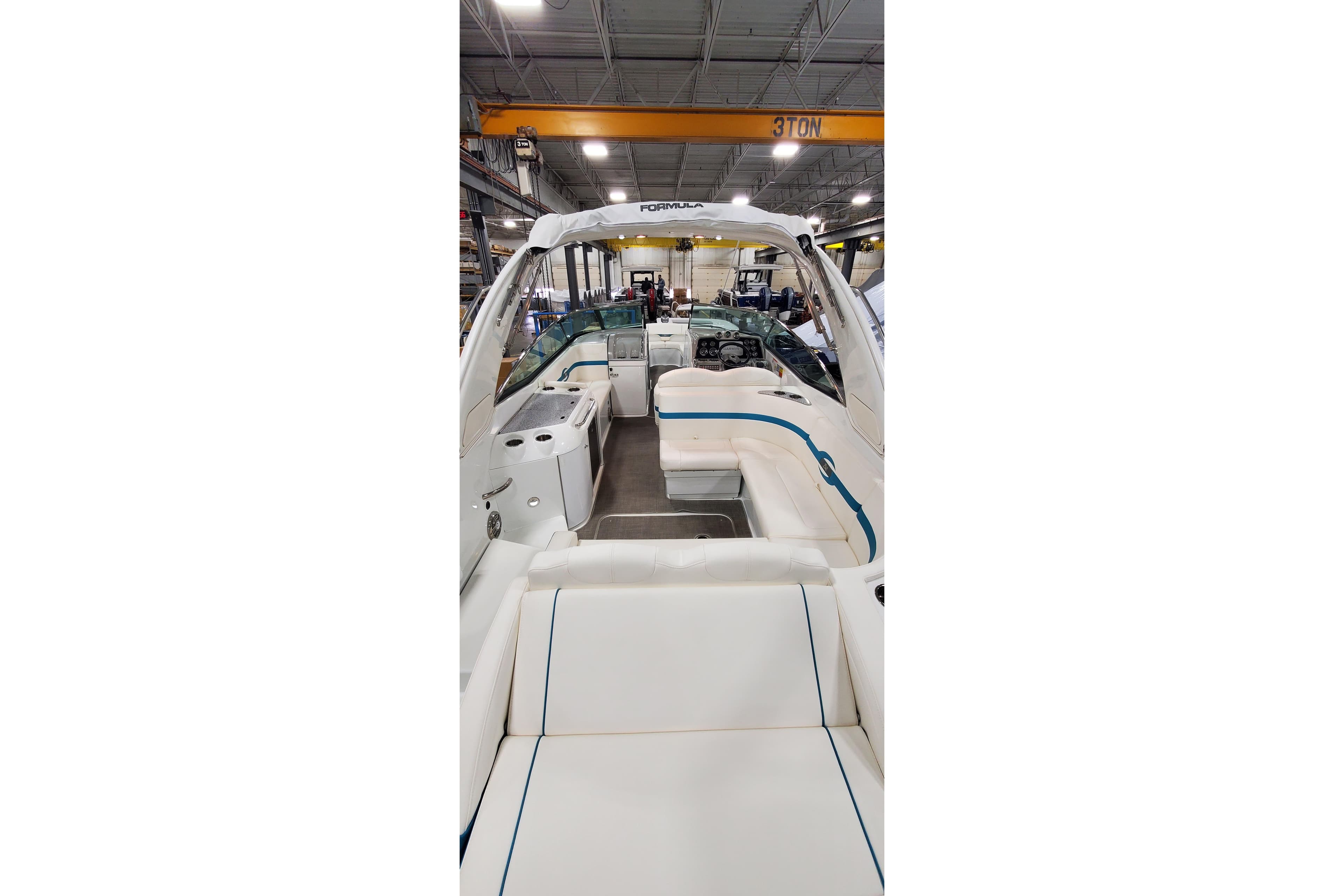 2009 Formula 310 Bowrider interior with white seating in a warehouse setting.