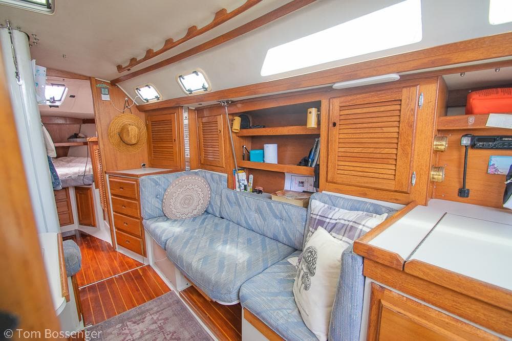 Interior of 1992 Catalina 36 sailboat with cozy seating and wooden cabinetry.