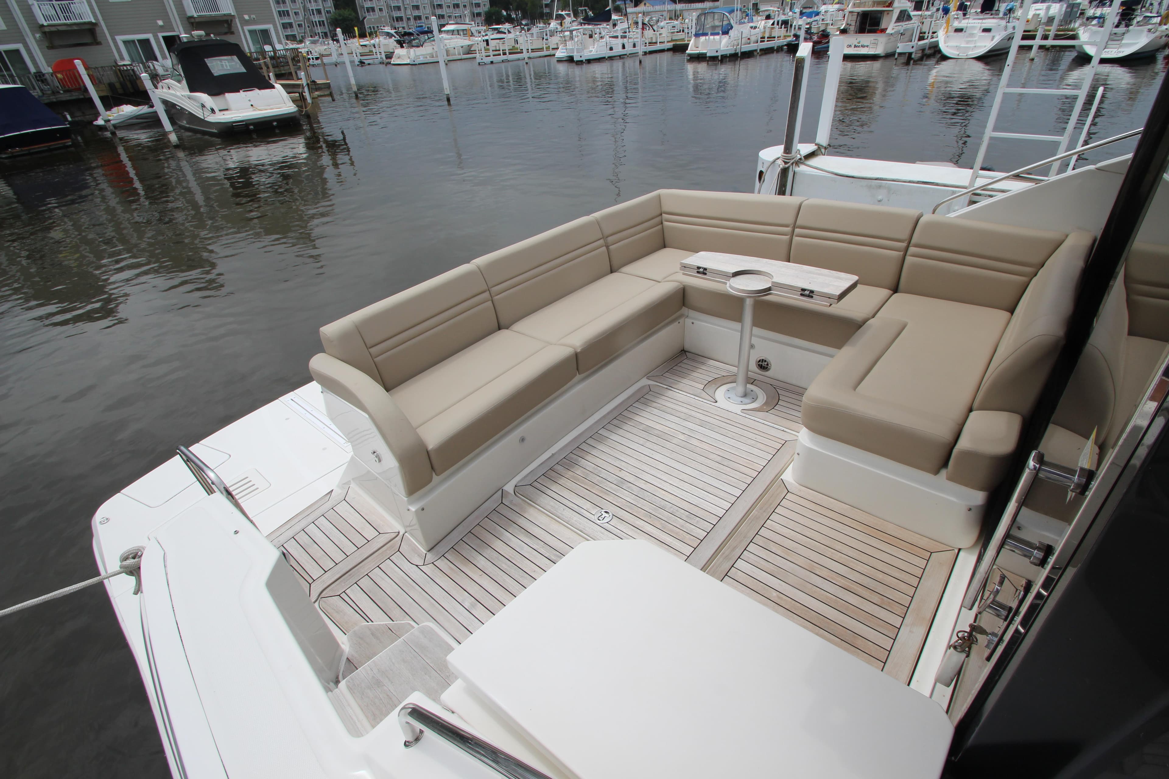 Luxurious seating area on 2016 Sea Ray 510 Sundancer yacht, docked at marina.