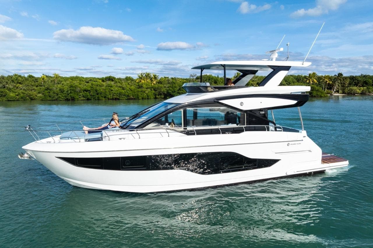 2026 Cruisers Yachts 50 Fly luxury yacht cruising on a serene waterway.
