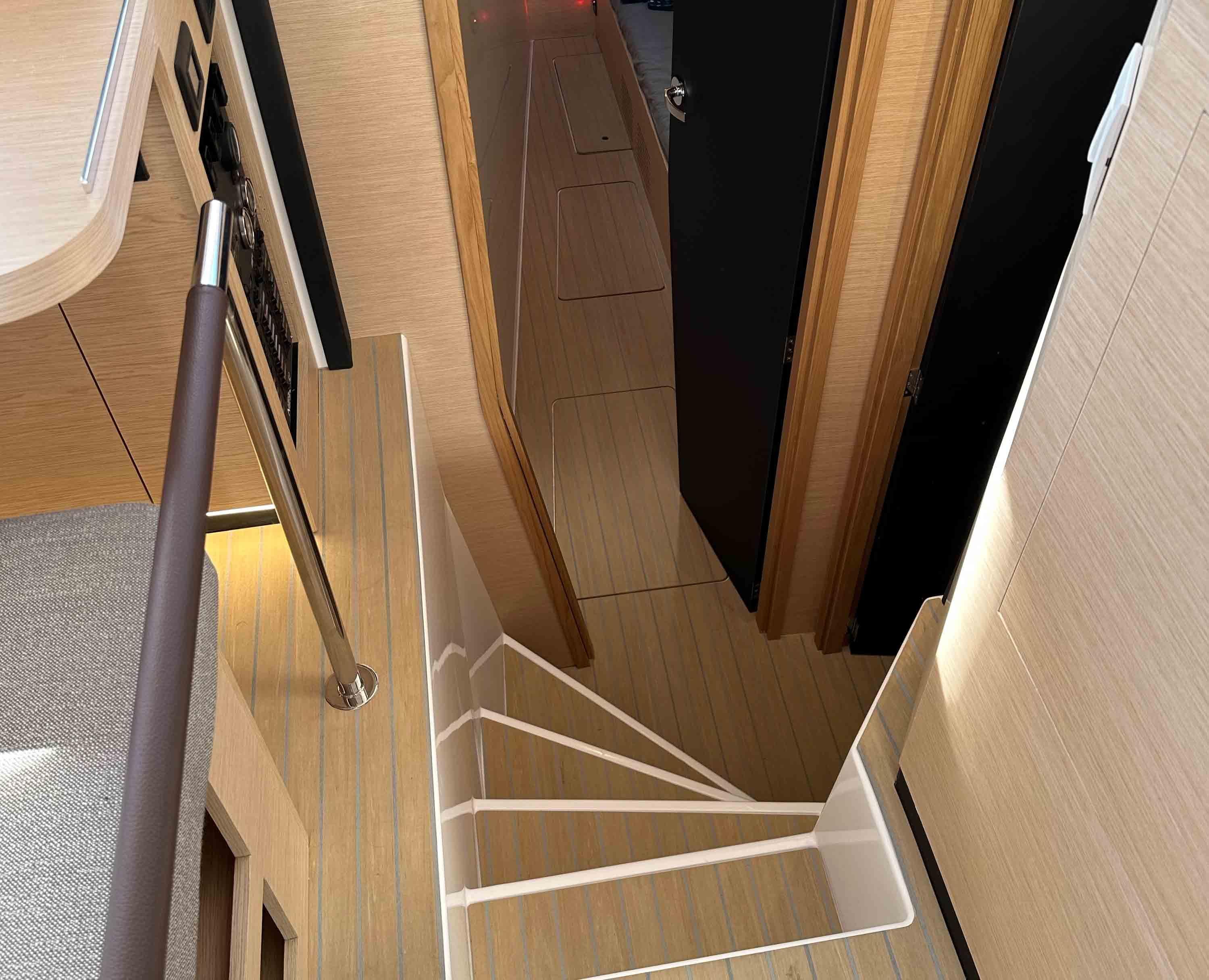 Interior of NEEL 52 yacht, 2025 model, featuring modern staircase and wooden finishes.