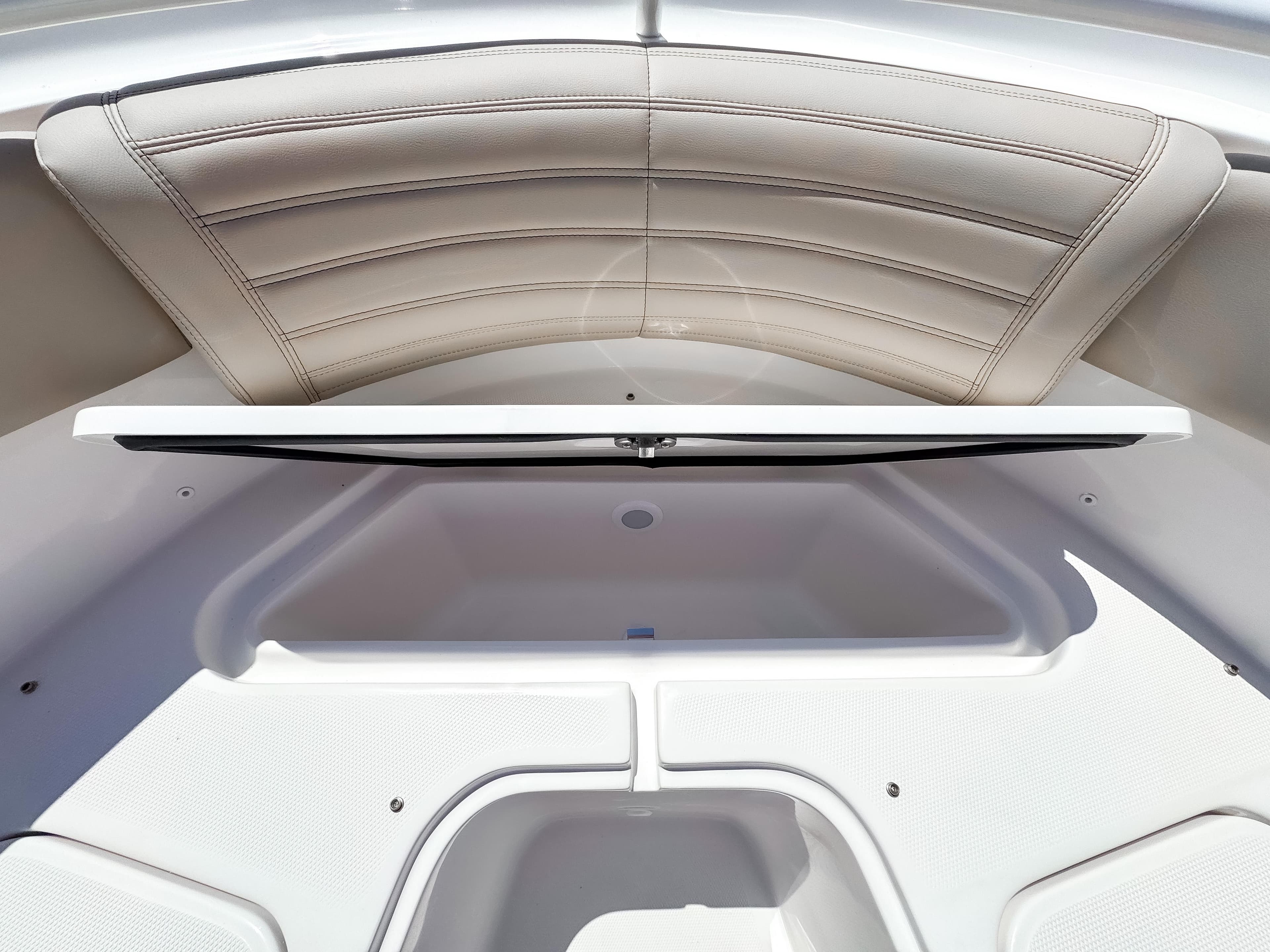 2025 Edgewater 325CC boat interior with open storage compartment and cushioned seating.