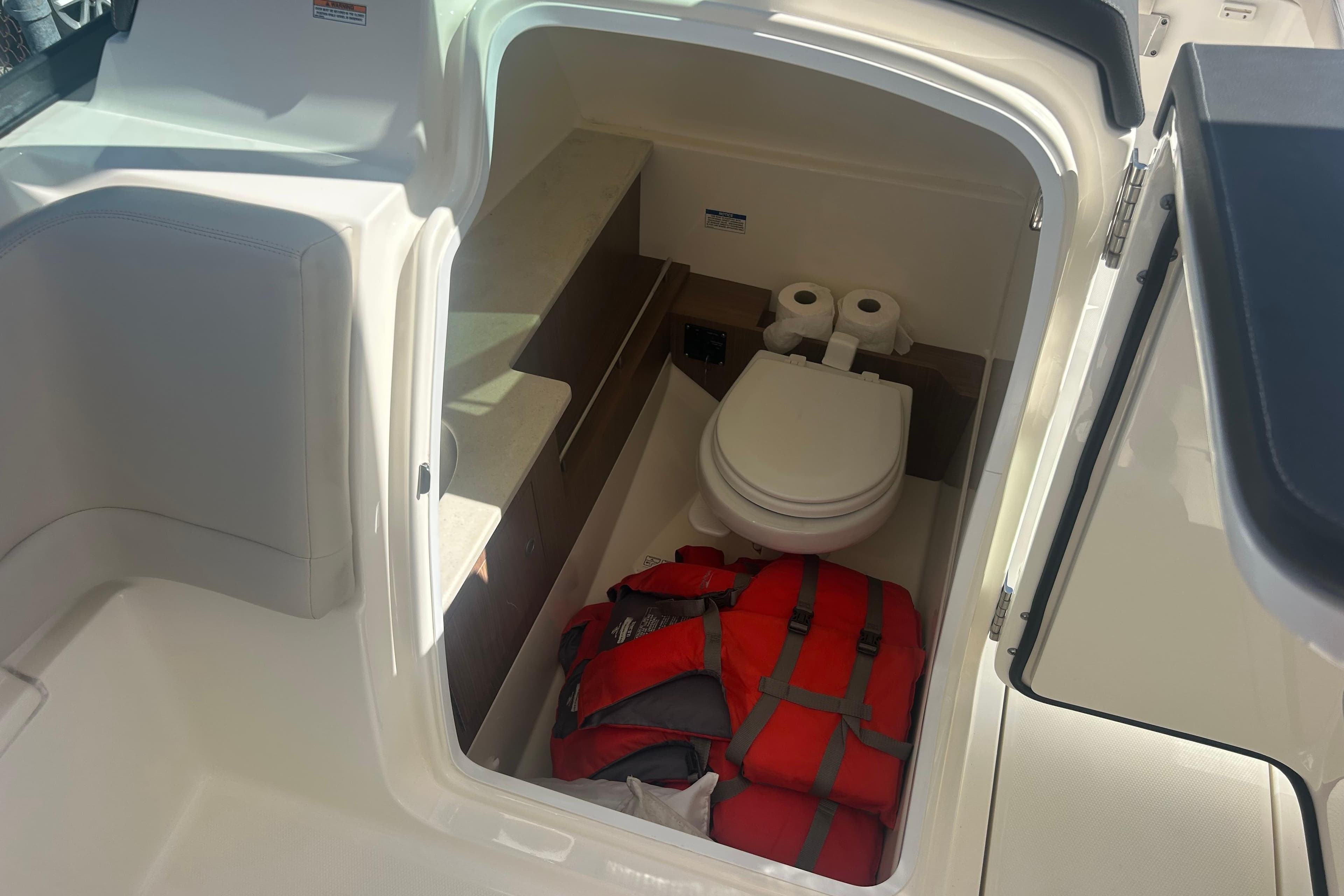 2018 Boston Whaler 270 Vantage boat interior with toilet and life jackets.