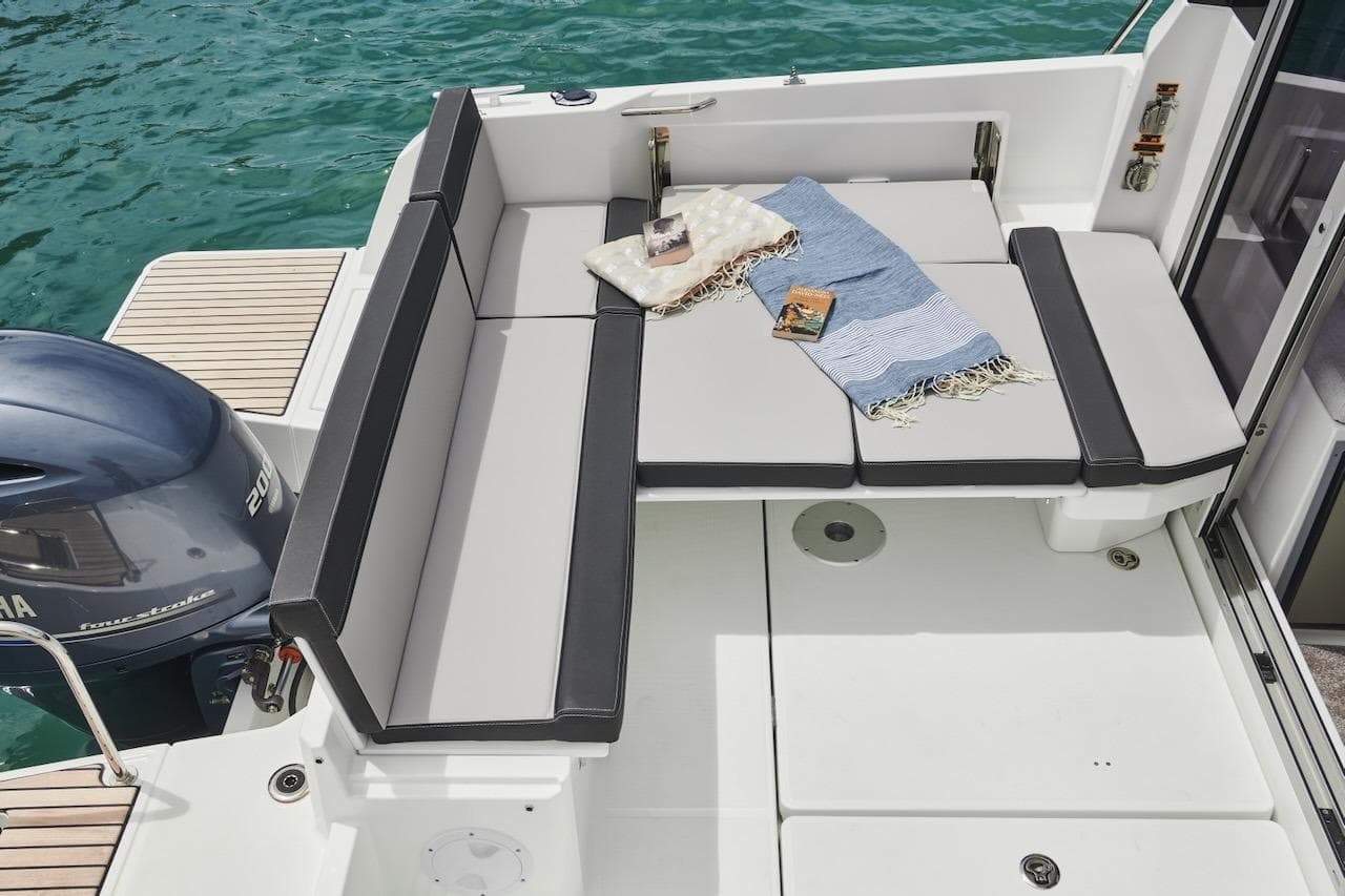 2025 Jeanneau NC 795 Series 2 boat interior with cushioned seating and Yamaha outboard motor.