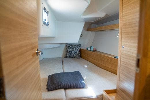 2024 X-Yachts X4-0 cabin interior with cozy bedding and wooden finishes.