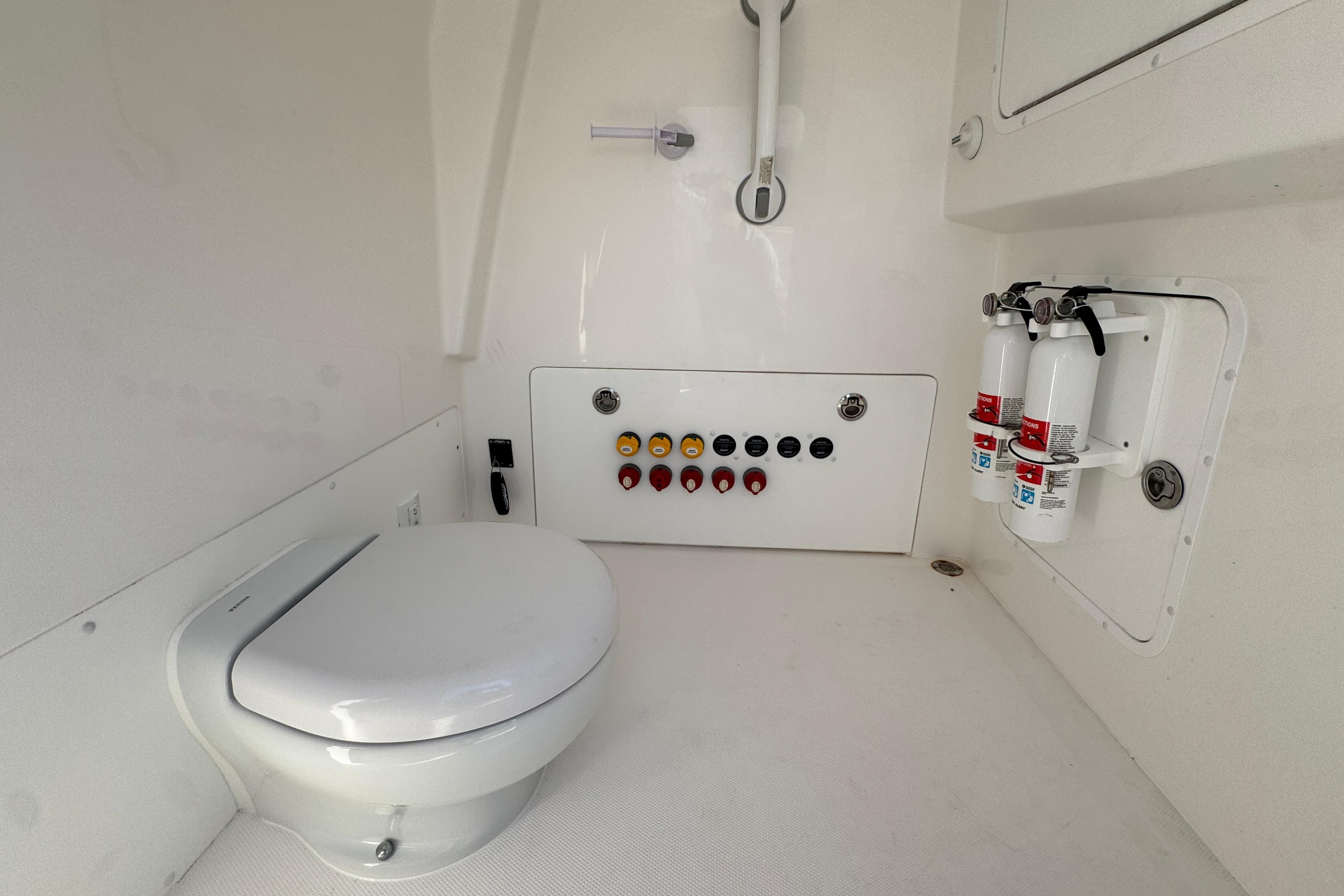 2023 Invincible 35 Catamaran interior with toilet, control panel, and fire extinguishers.