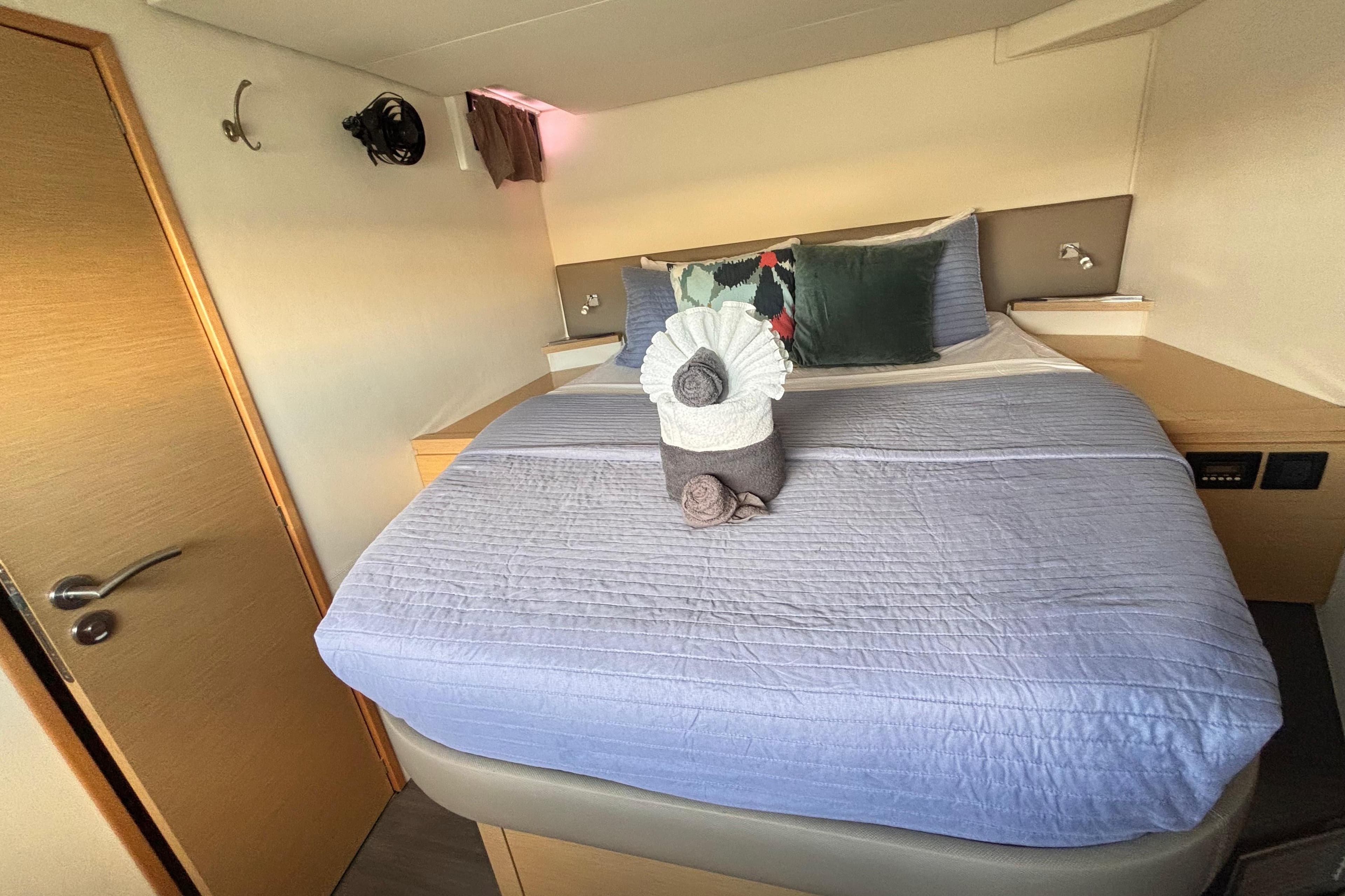 Luxurious cabin interior of 2016 Fountaine Pajot SABA 50 catamaran with neatly arranged bed.