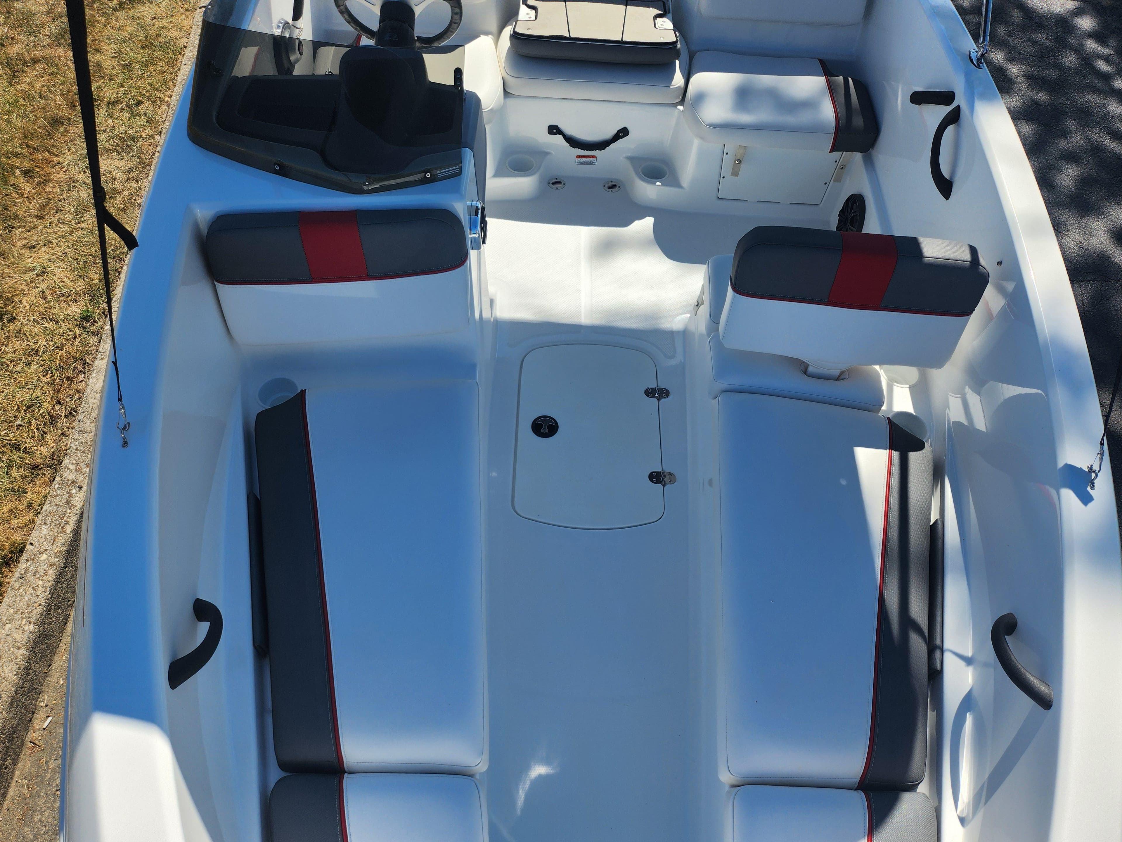 2021 Tahoe T16 boat interior with white and gray seating, red accents, and steering console.