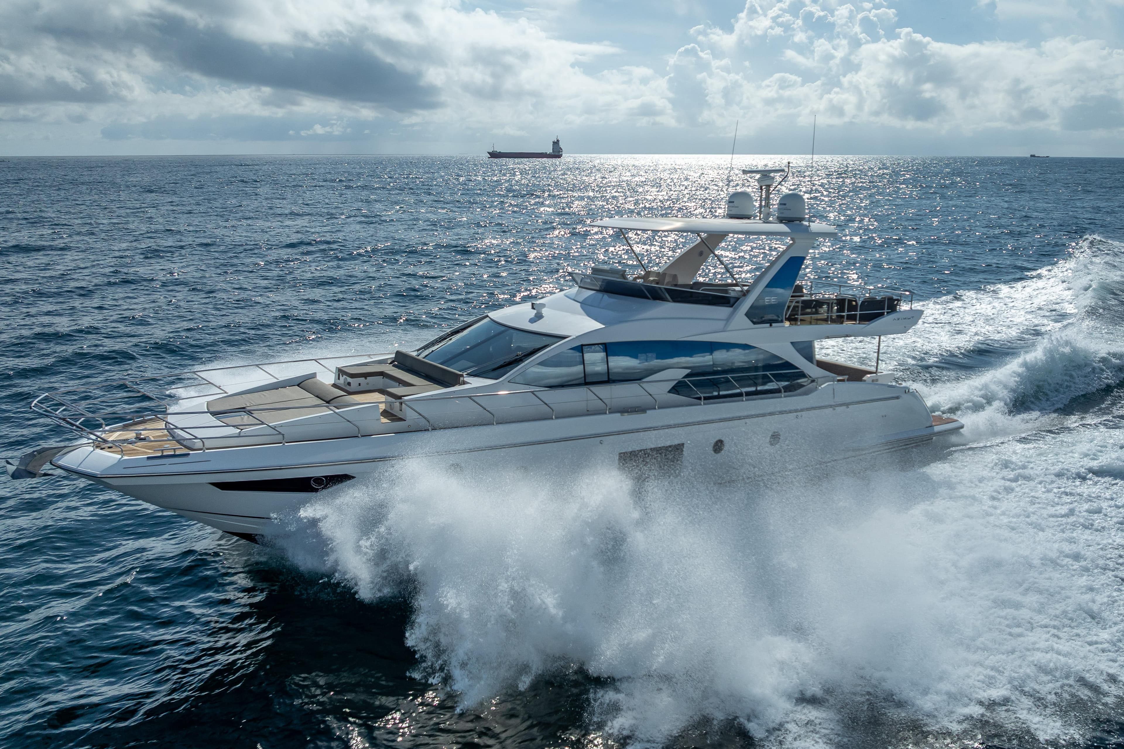 Luxurious 2019 Azimut 66 yacht cruising through ocean waves under a cloudy sky.