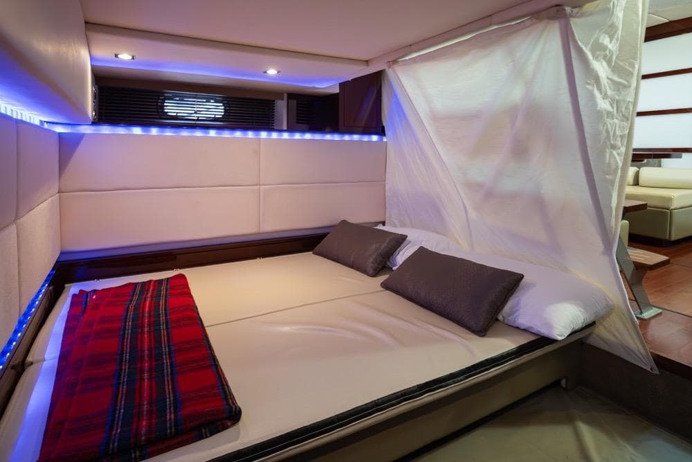 Luxurious cabin interior of 2010 Sea Ray 450 Sundancer yacht with cozy bedding.