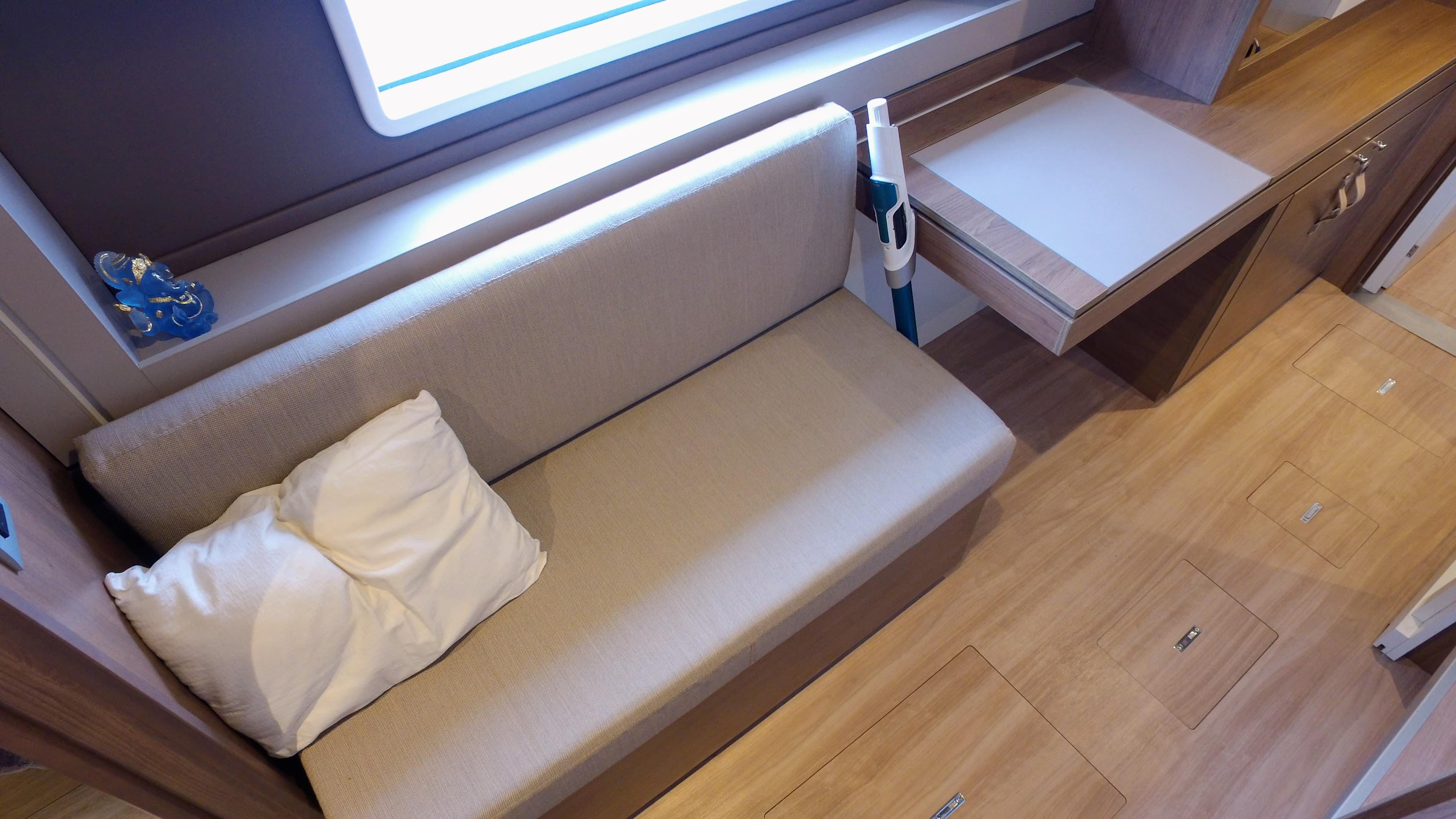 Interior of 2022 Bali 4.2 yacht with beige sofa and wooden flooring.