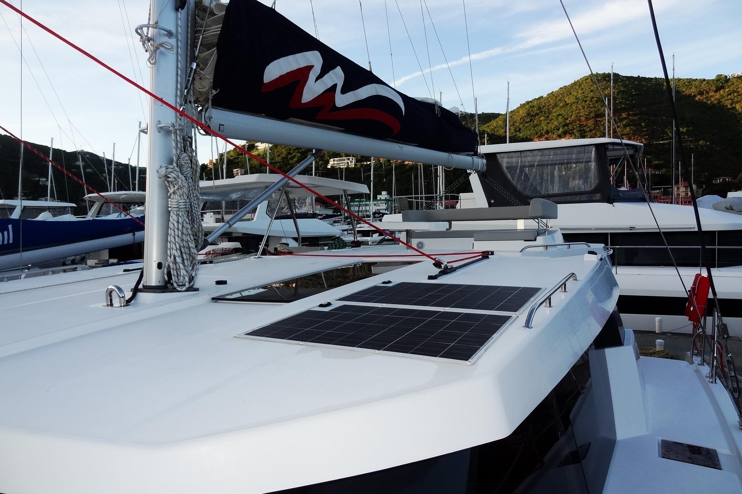 2024 Robertson and Caine Leopard 42 catamaran with solar panels, docked in a marina.