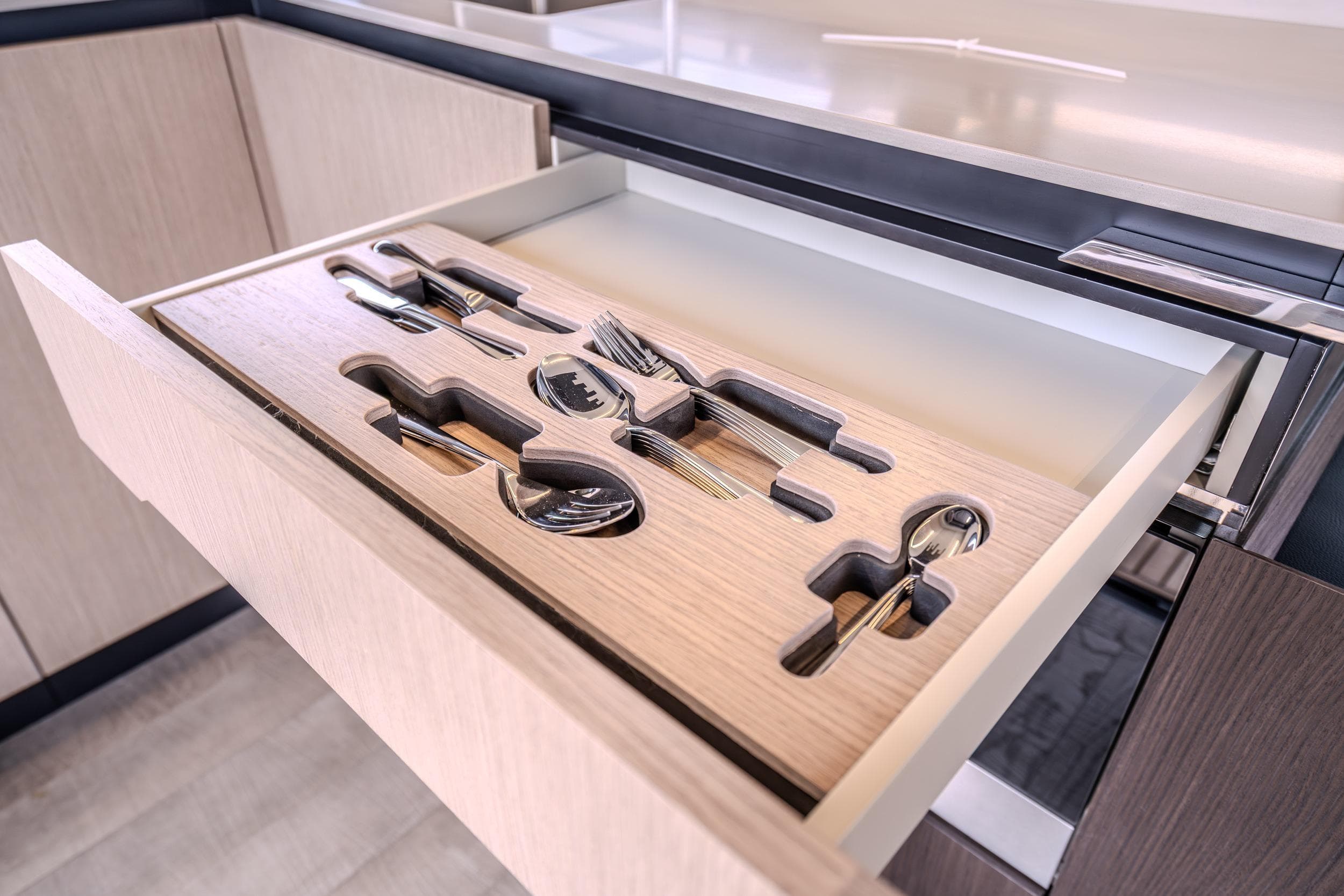 Open kitchen drawer with organized cutlery in Absolute 48 Coupe, 2026 model.