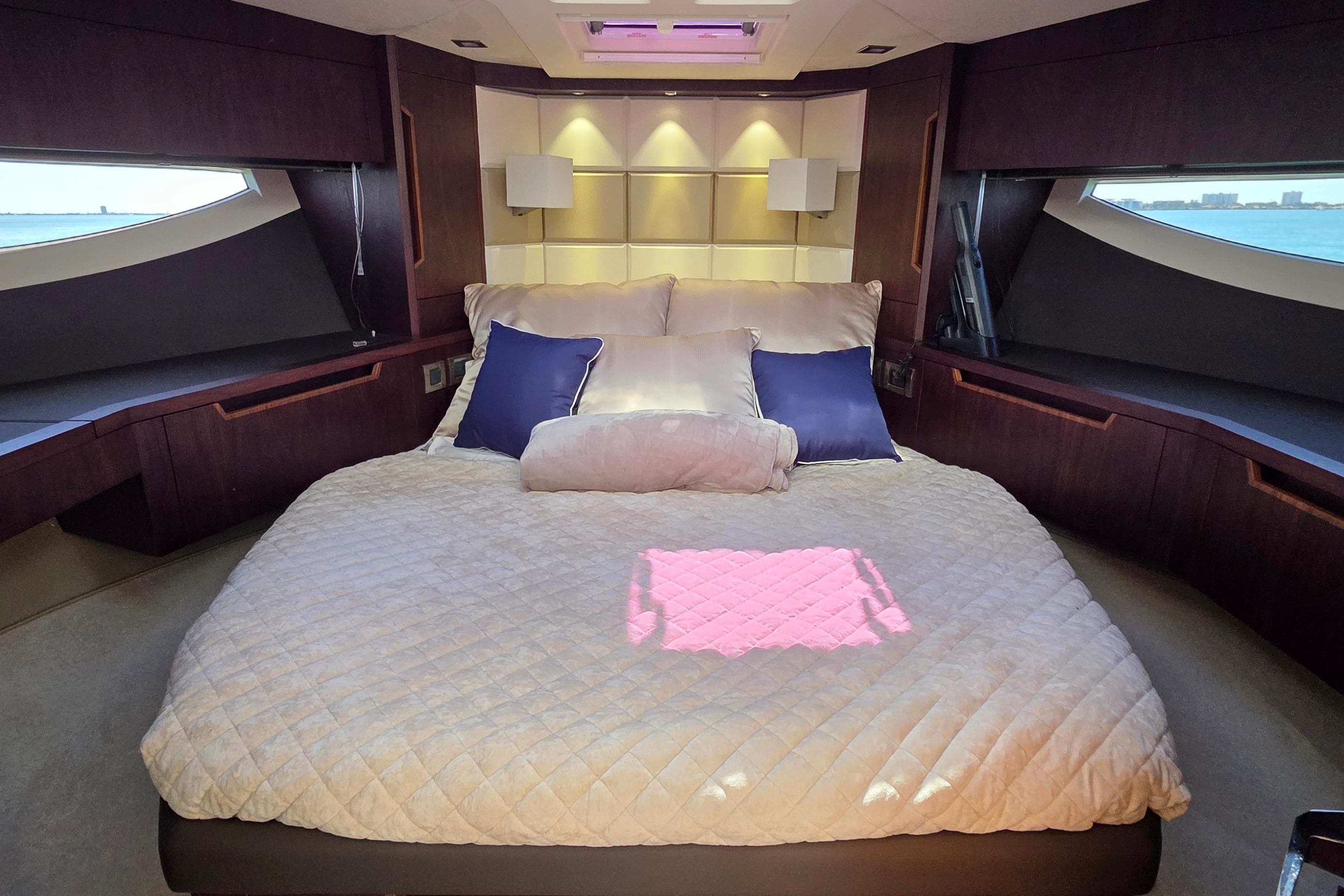 Luxurious bedroom interior of 2022 Galeon 500 Fly yacht with elegant bedding and ocean view.