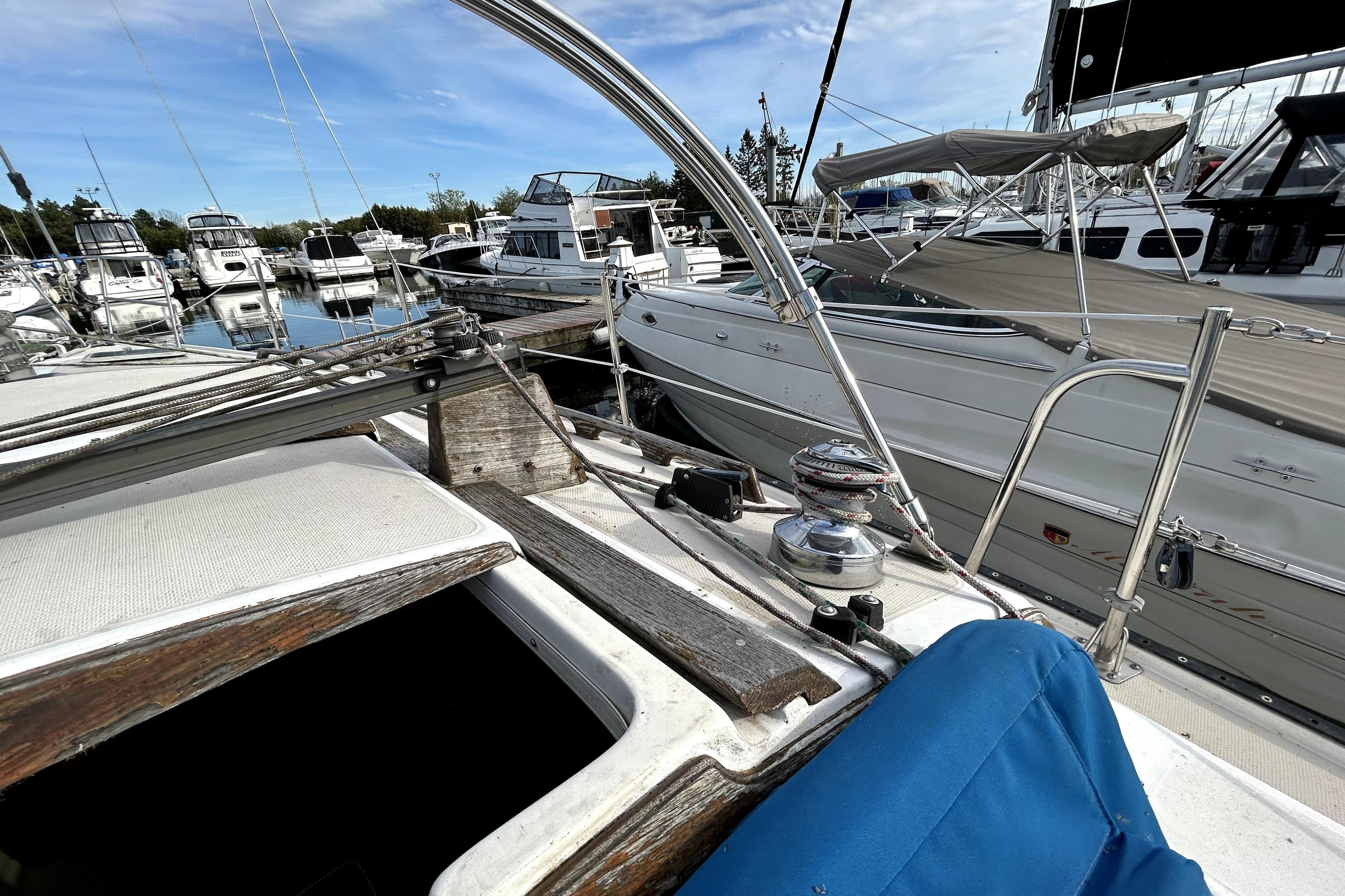 1986 Catalina 30 sailboat docked in a marina, surrounded by other boats.