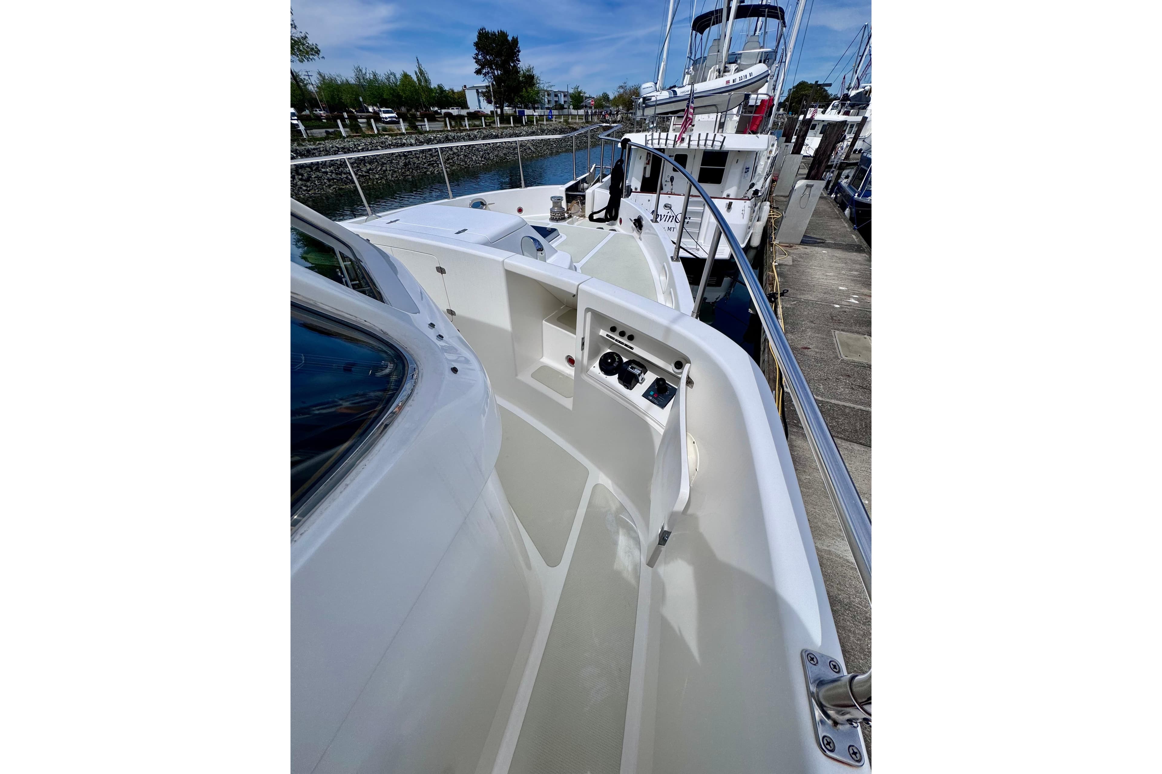 Nordhavn 50 yacht deck, 2000 model, docked at marina under clear blue sky.