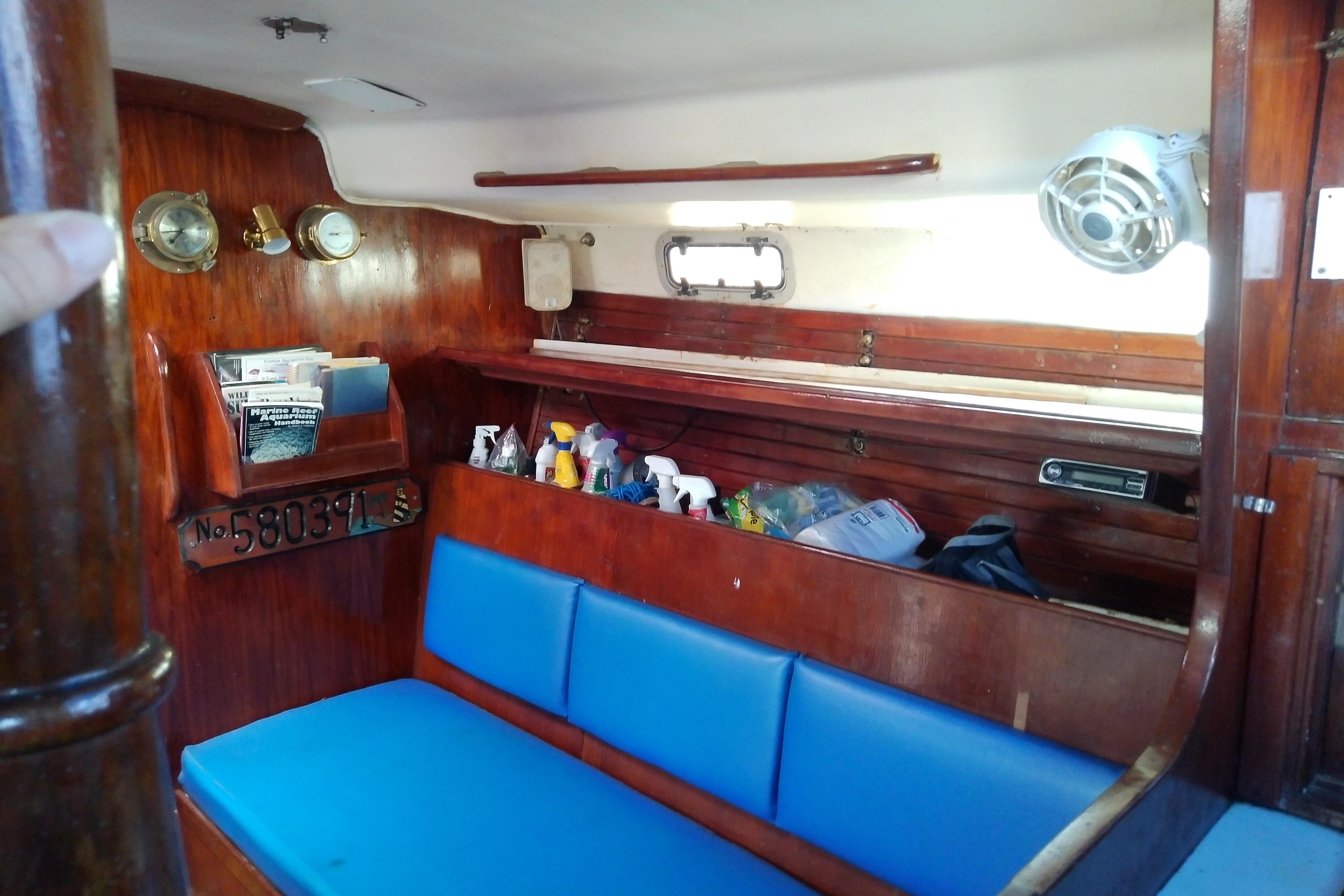 Interior of a 1972 Morgan Out Island 41 sailboat with blue seating and wooden accents.