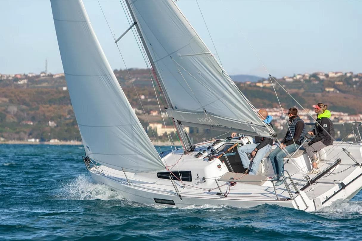 2024 Beneteau First 27 sailboat with crew navigating coastal waters.