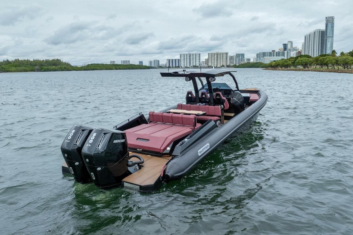 Skipper-BSK 42 boat, 2023 model, on water with city skyline in background.