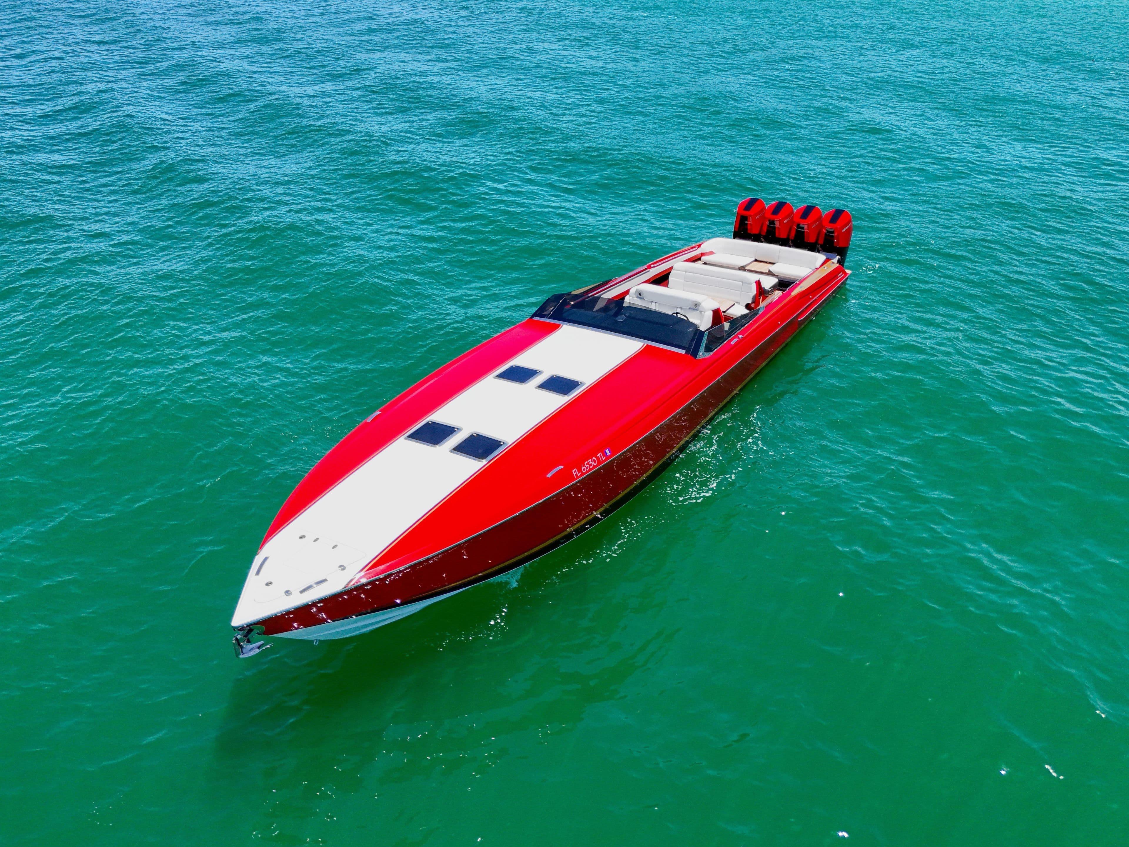 2023 Nor-Tech 55 Flyer speedboat on clear blue water, showcasing sleek red design.